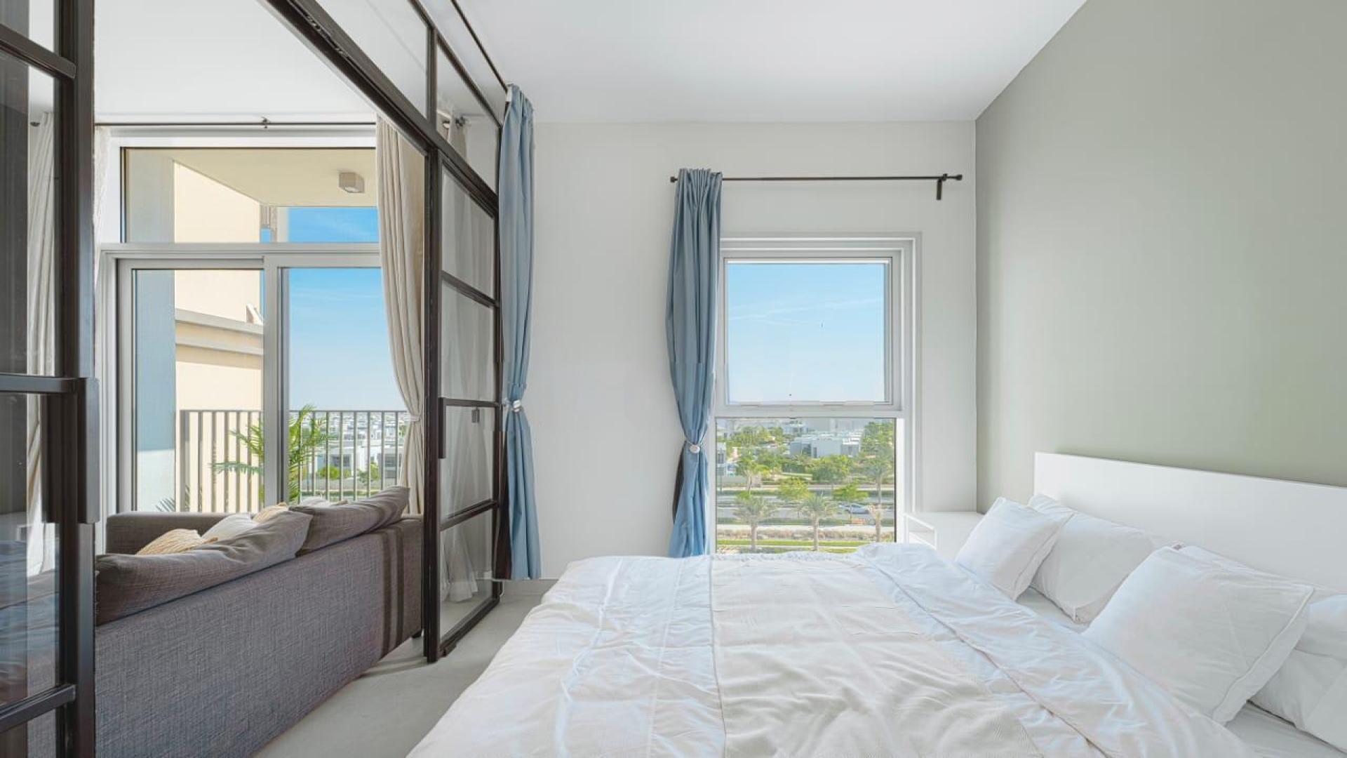 Modern living room in Dubai Hills Estate apartment, featuring large windows and sleek furnishings
