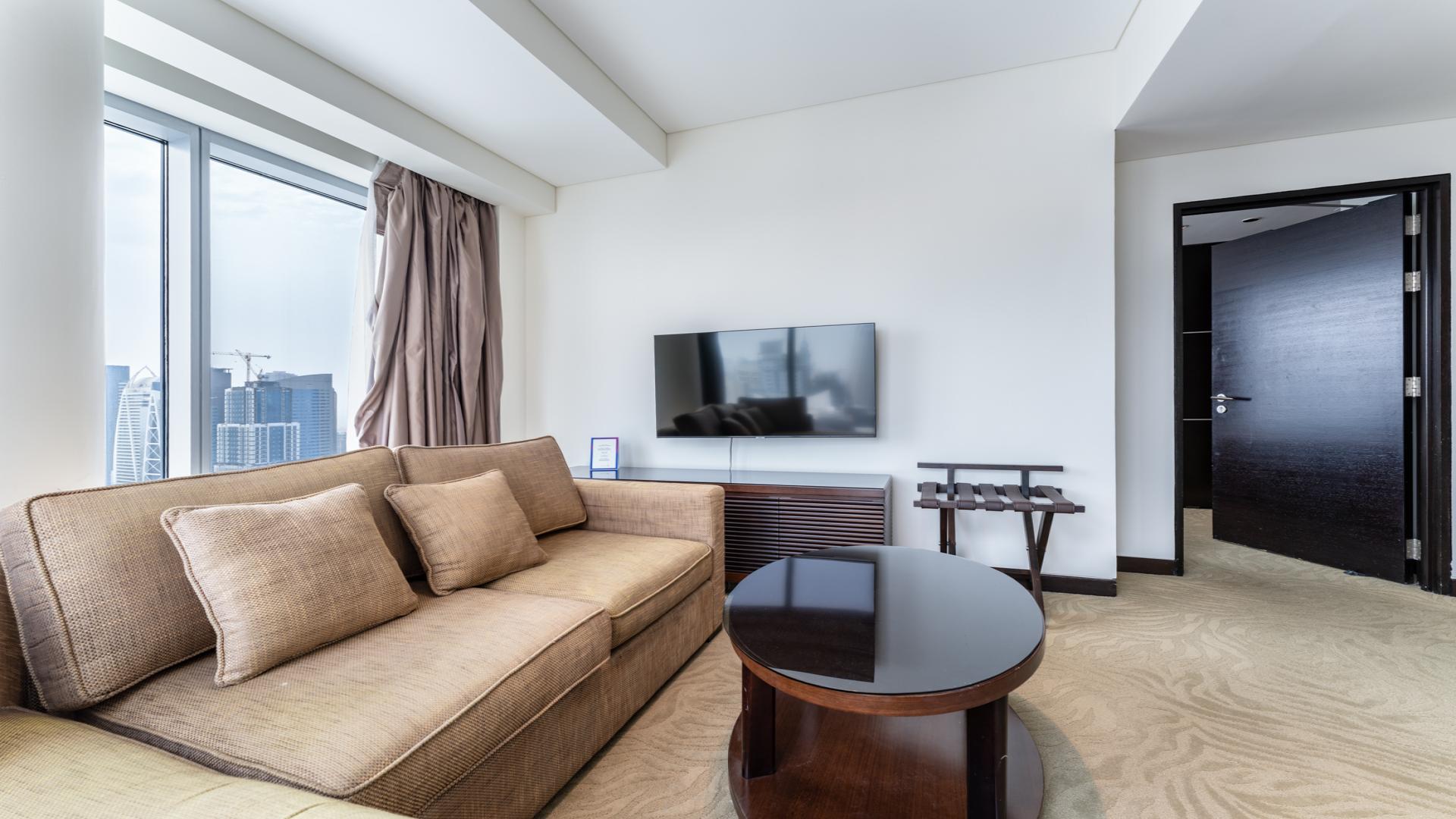 Modern living room in Dubai Marina apartment for rent, featuring elegant furnishings and large window