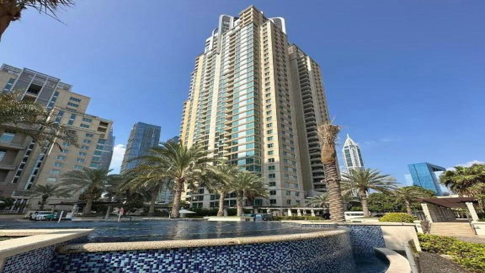 Furnished living room in Dubai Marina apartment, featuring modern decor and large window view