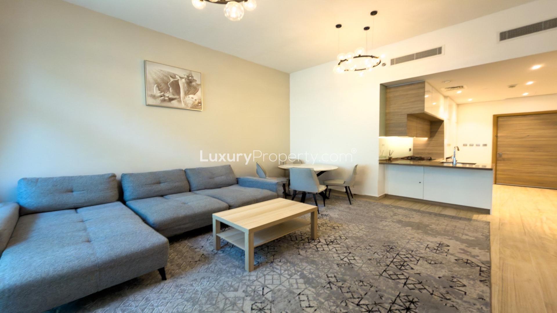 Modern living room in Studio One Tower apartment, Dubai Marina, with large sofa and TV