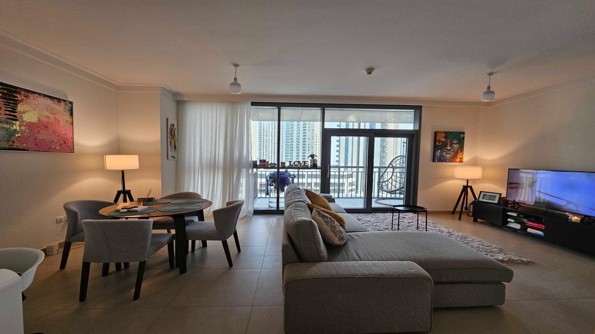 Modern living room in Dubai Creek Harbour apartment with large windows and stylish decor