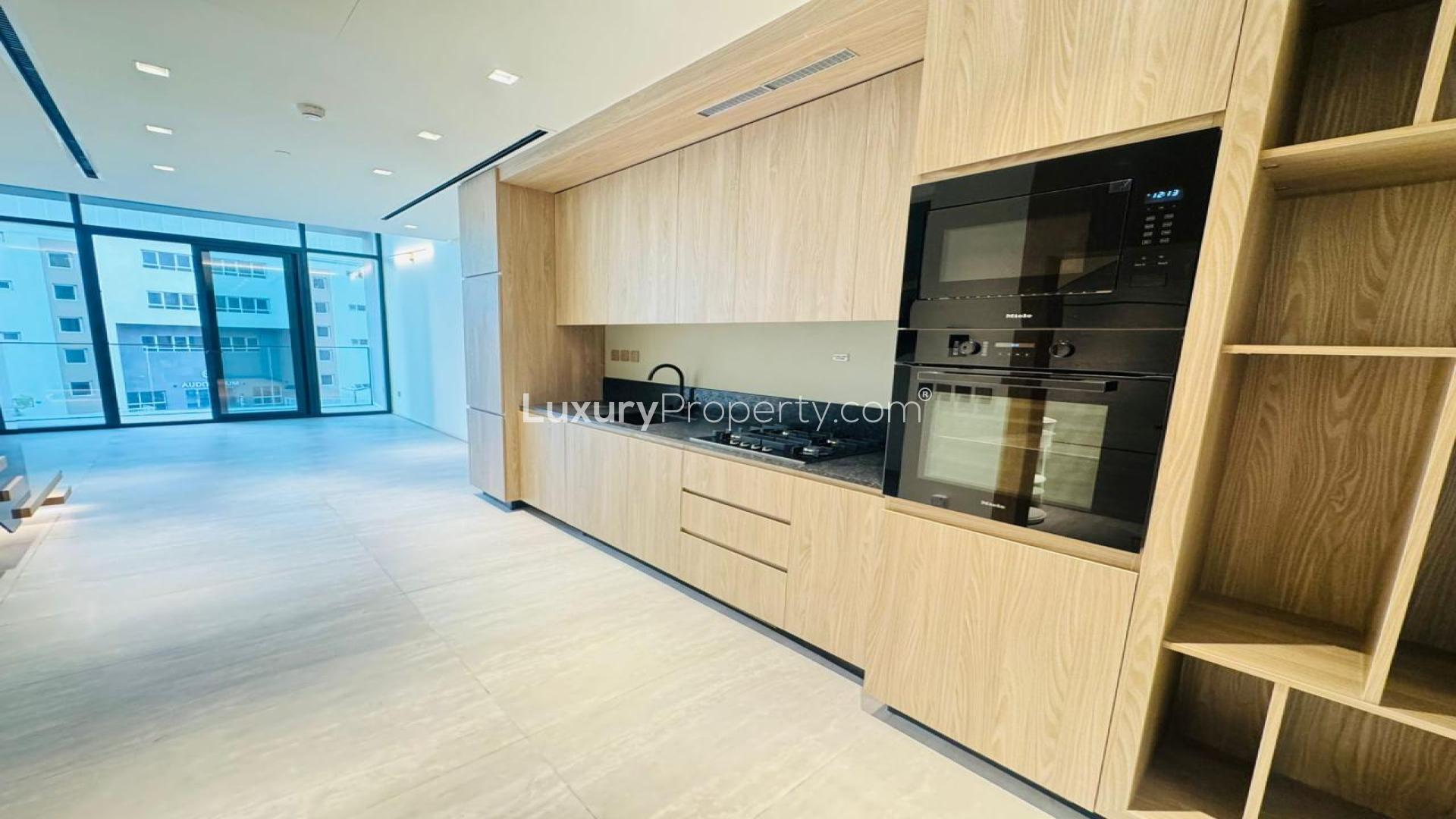 Unfurnished one-bedroom apartment interior with large windows in JVC, The Autograph