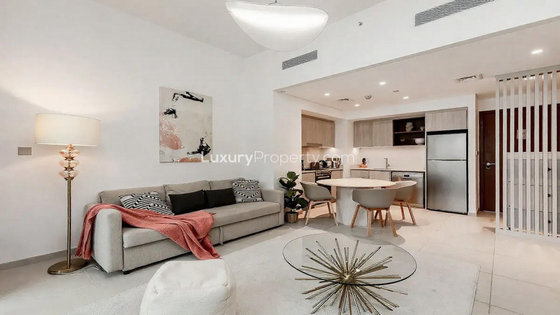 Modern living room in Vida Creek Harbour apartment, Creek Beach. Cozy seating with balcony view