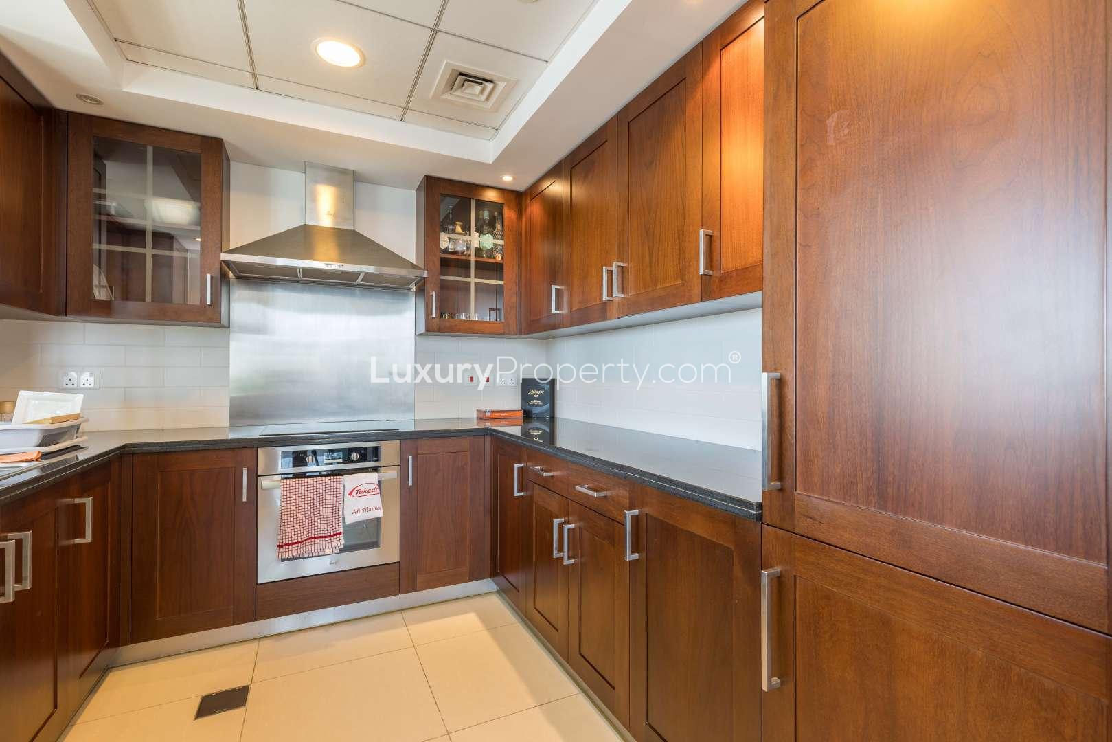 Modern kitchen with wooden cabinets in Downtown Dubai apartment, 29 Burj Boulevard