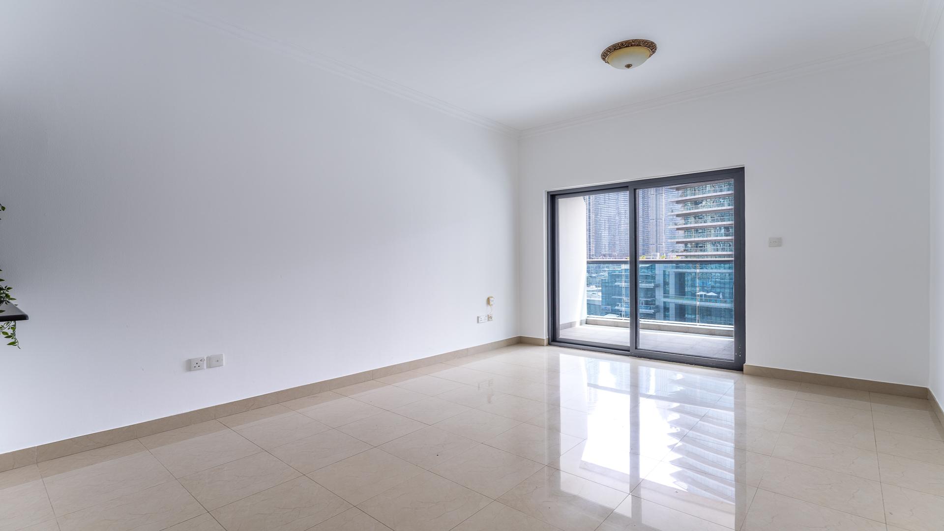 Empty living room in Time Place Tower apartment, Dubai Marina, with tiled flooring