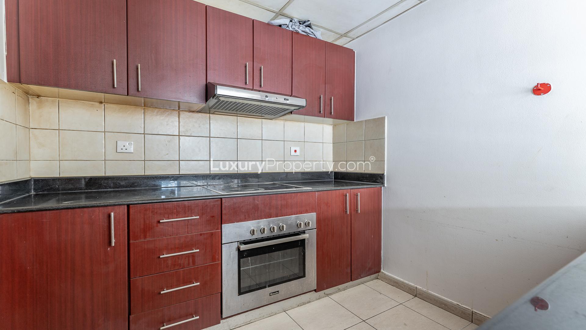 Empty living room with tiled floor, large window, view of Dubai Marina skyline