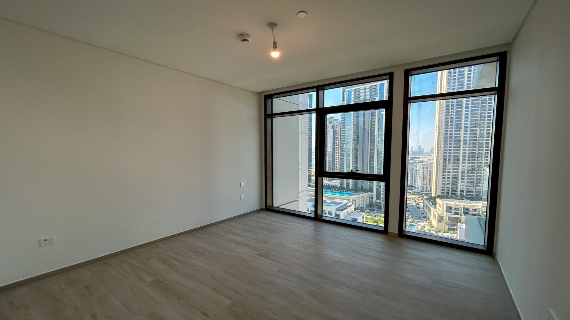 Modern 1-bedroom apartment interior with kitchen and large windows in Palace Residences, Dubai Creek