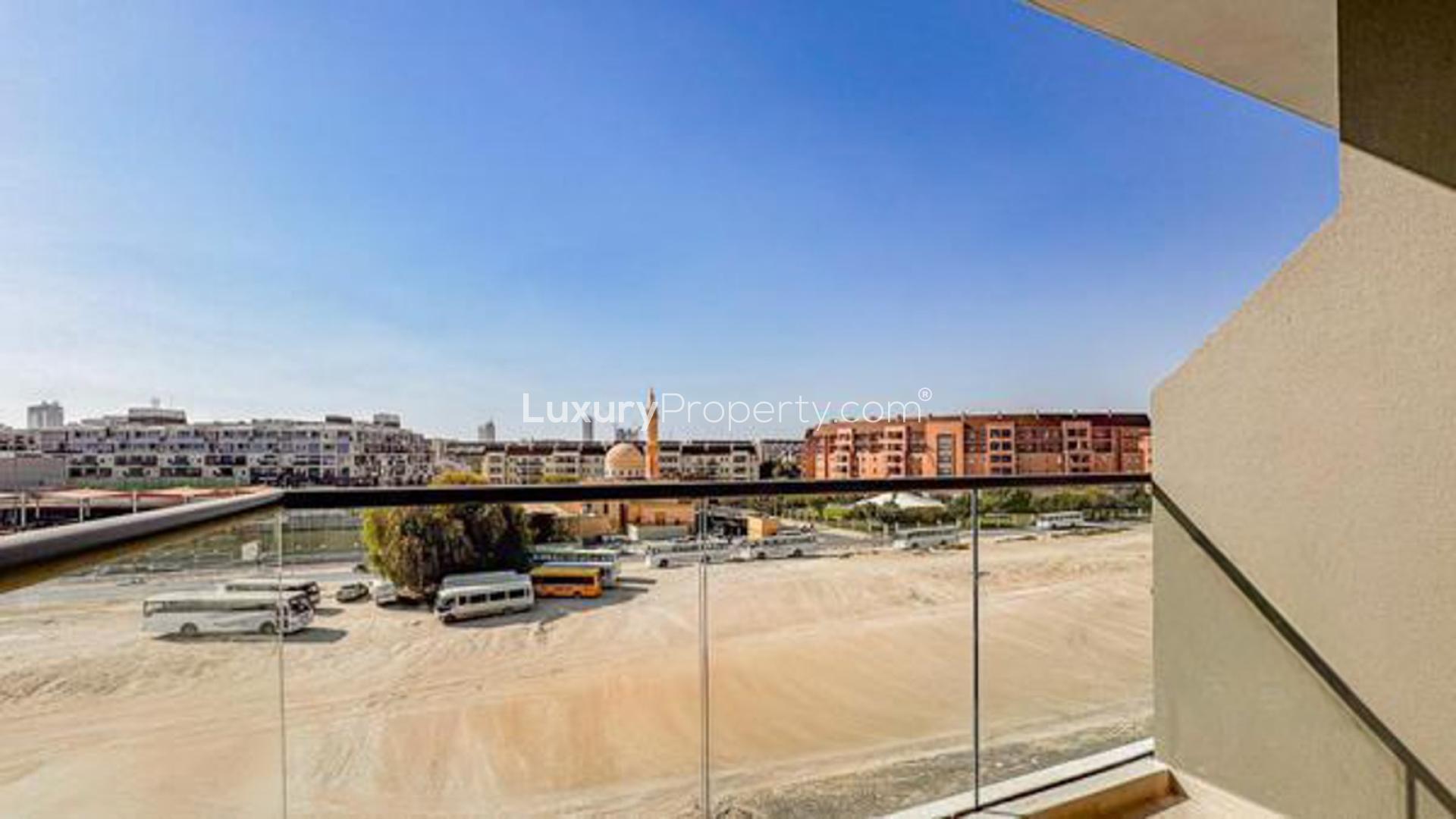 Modern bedroom in Laya Heights apartment, Dubai Studio City, featuring cozy bed and seating area