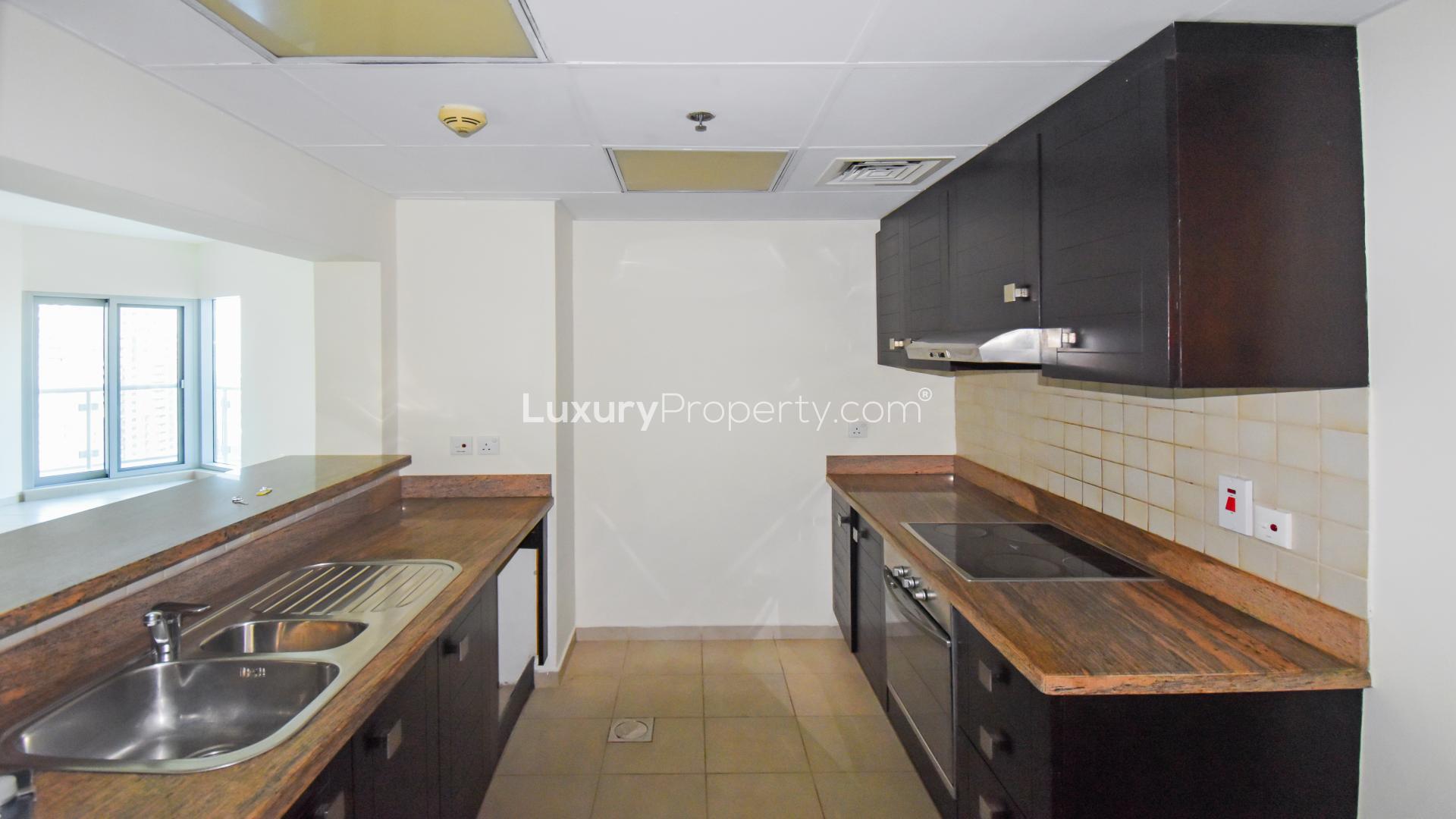 Empty room with large windows offering Marina skyline view in Al Habtoor City apartment