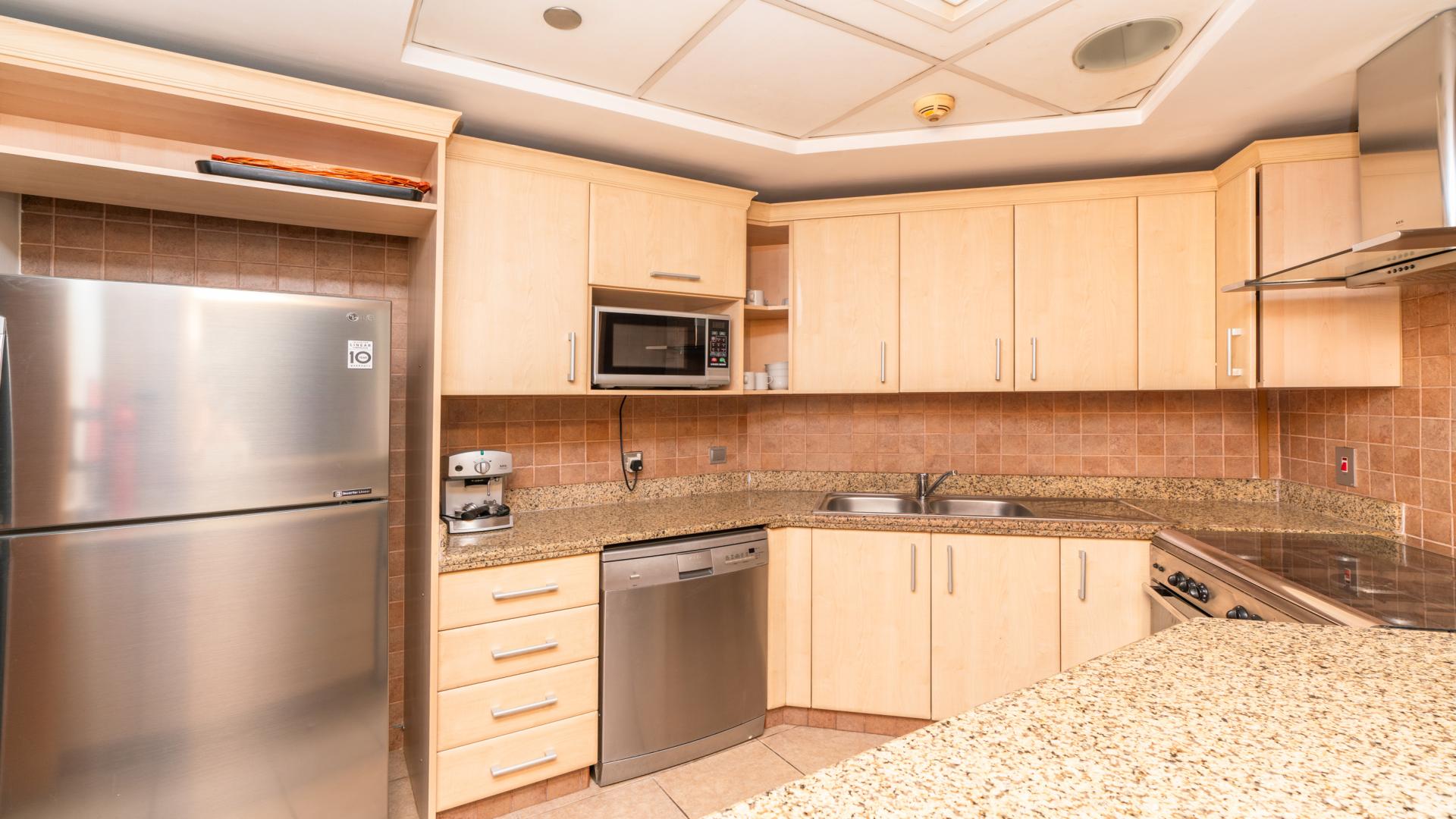 Modern kitchen in 1-bedroom furnished apartment, Al Das, Palm Jumeirah, featuring granite countertops