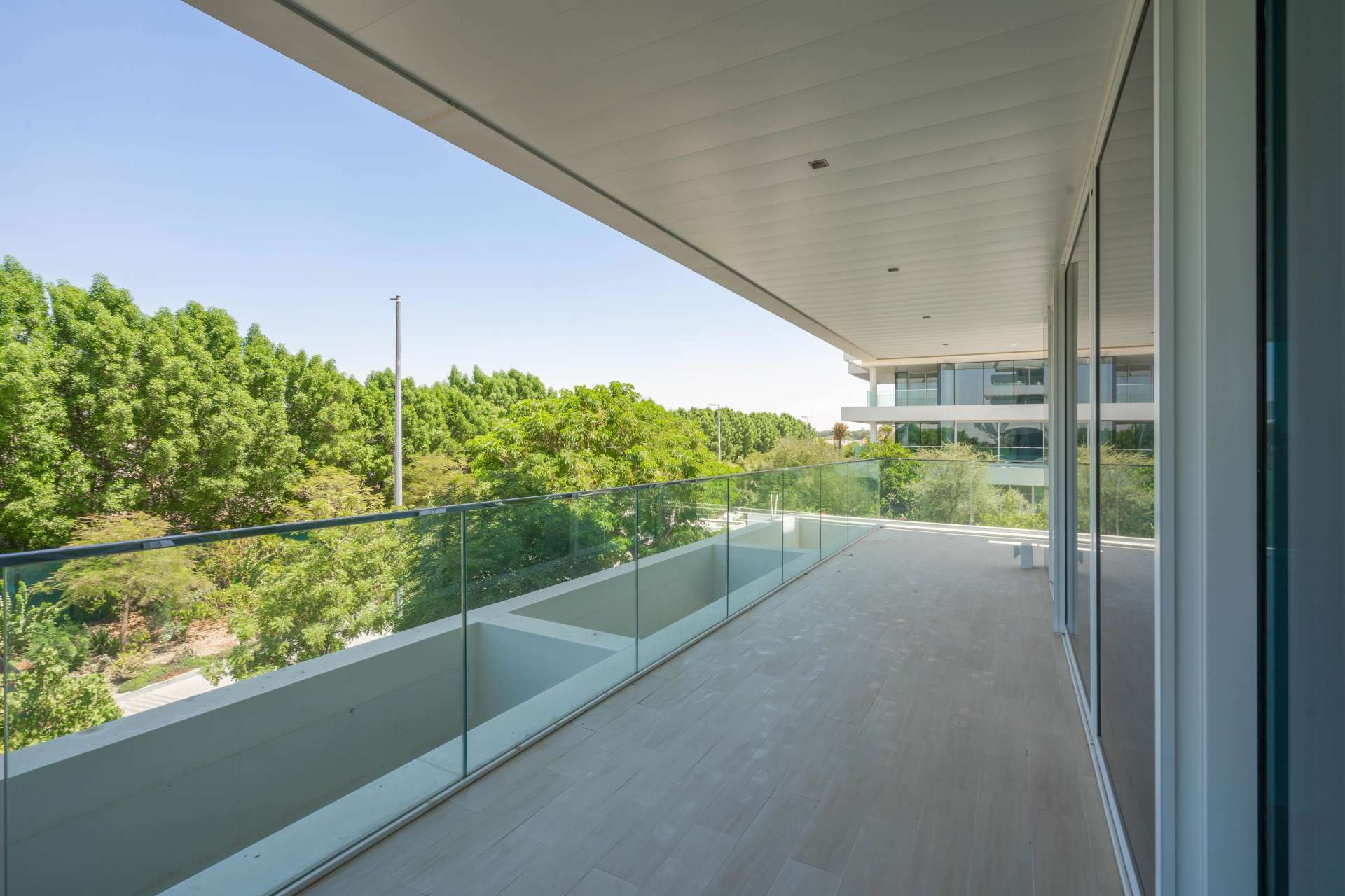 Modern kitchen in 1-bedroom Ashjar apartment, Al Barari, featuring sleek design and large windows