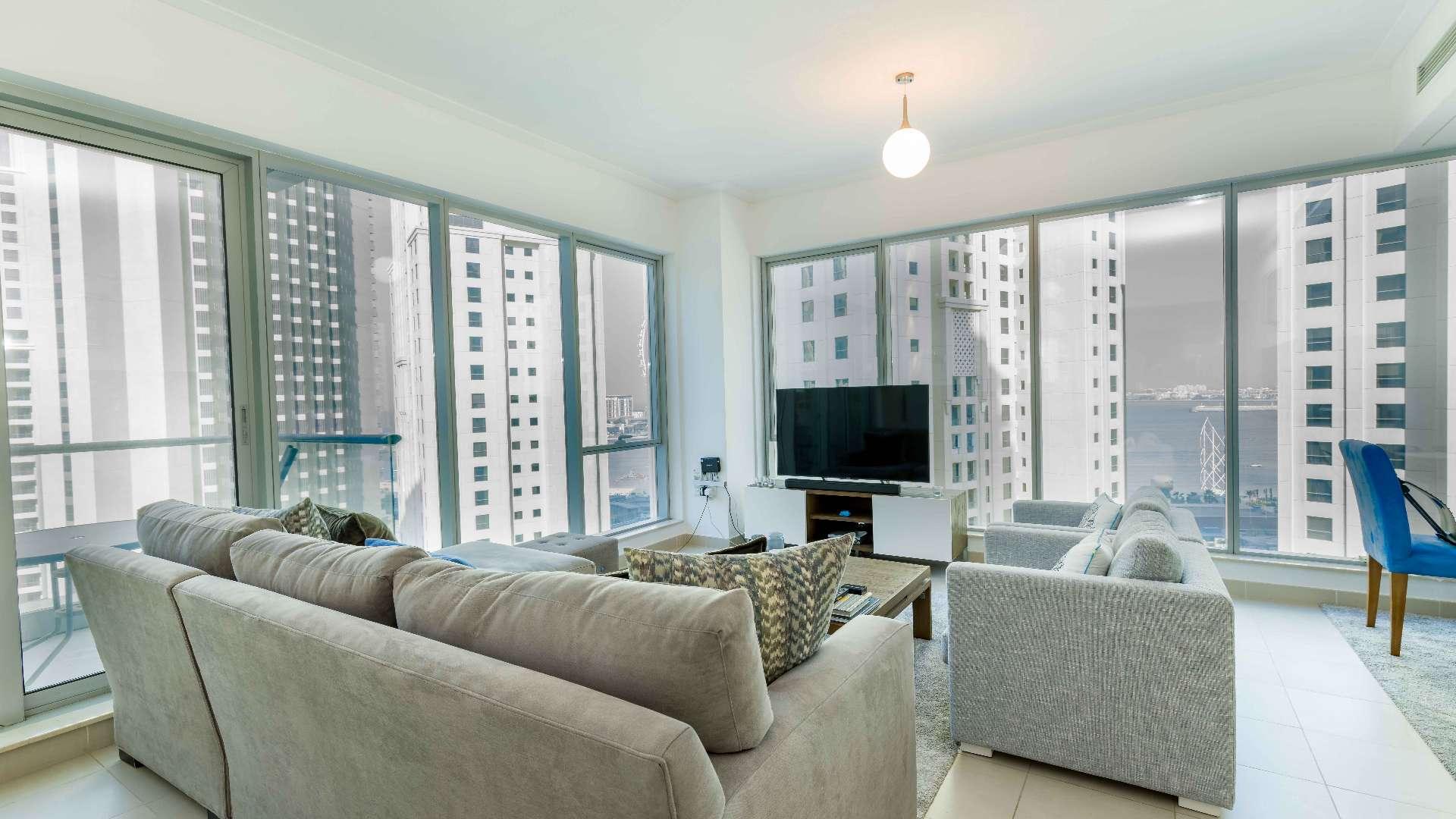 Modern living room in Dubai Marina apartment with city view through large windows