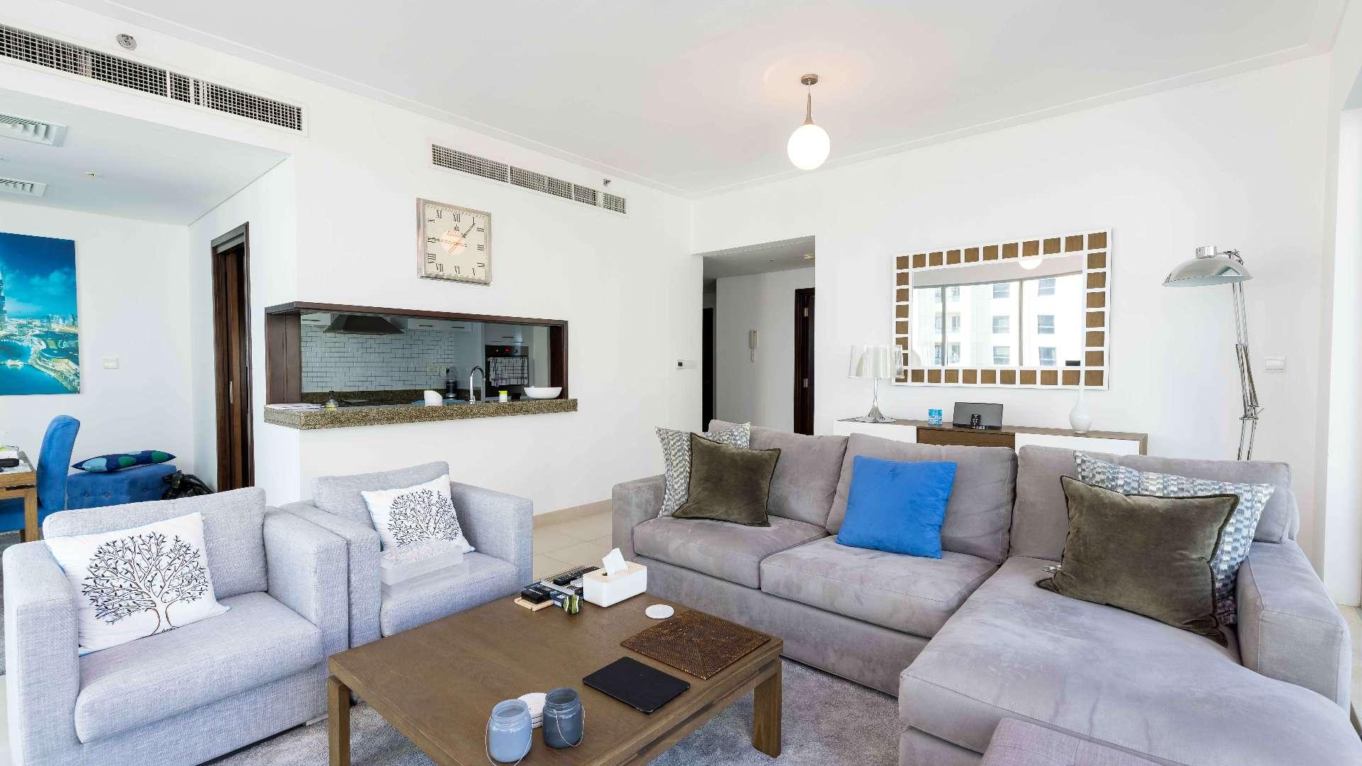 Modern living room with sea view in Dubai Marina apartment, large windows, cozy seating