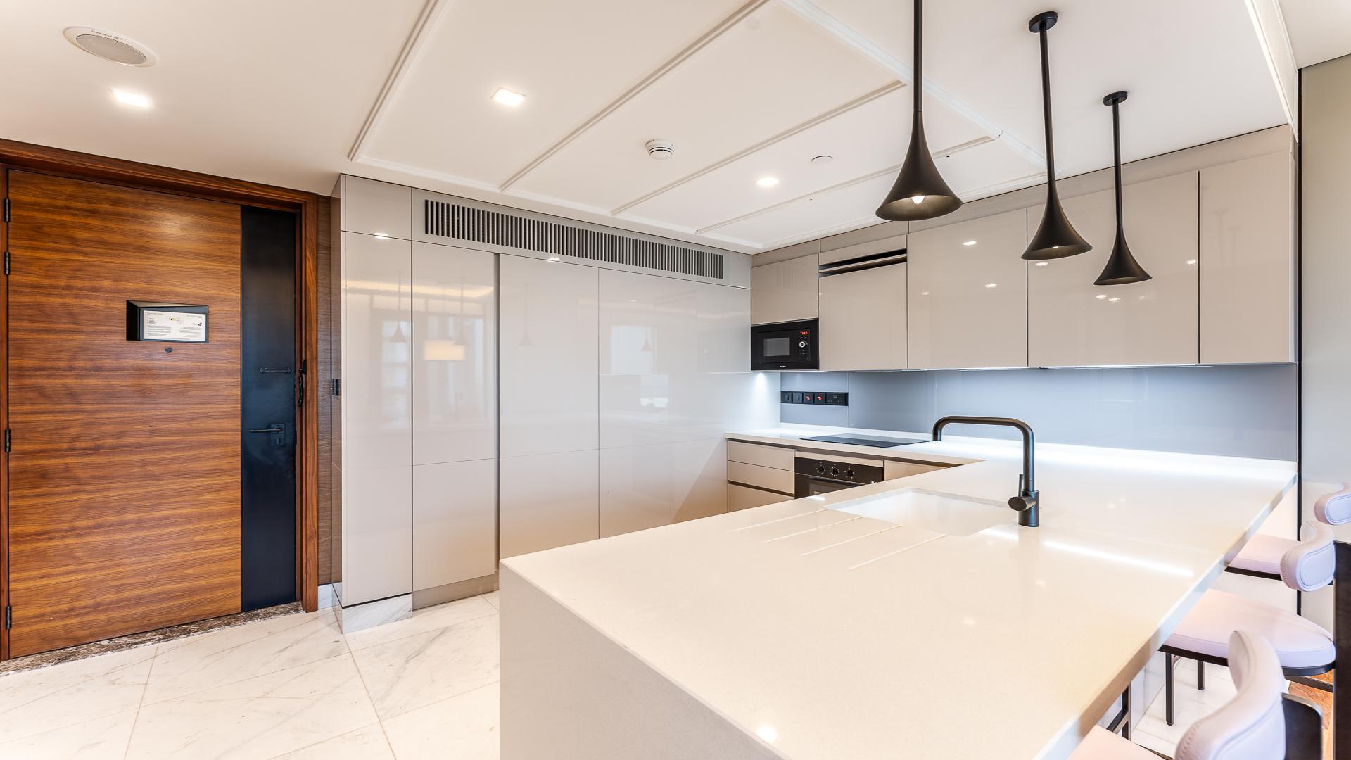 Modern living room and kitchen in Bluewaters apartment, Dubai, with sleek wood accents