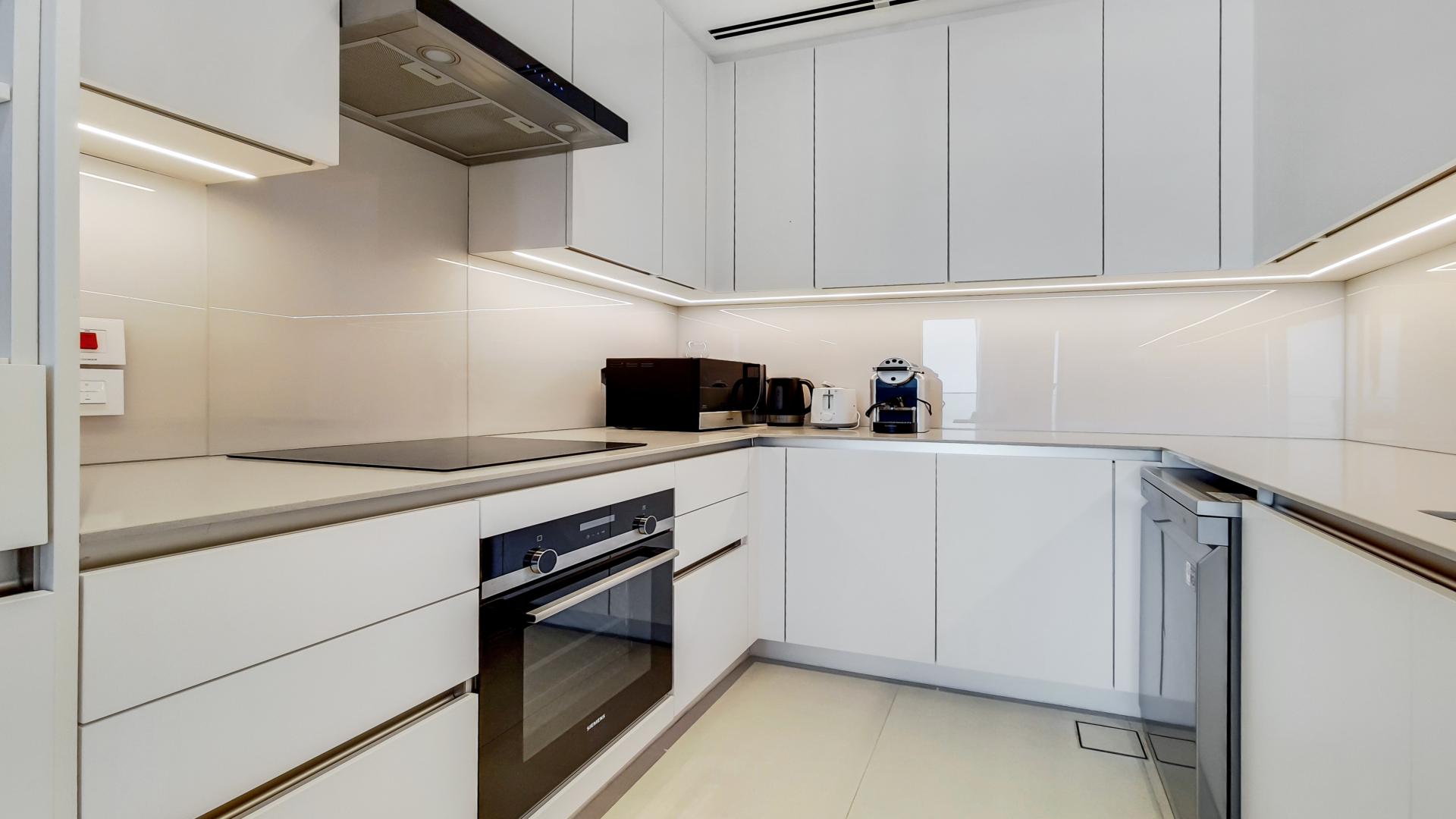 "Modern living room in furnished 1-bedroom apartment, Address Jumeirah Gate, Jumeirah Beach Residence.",Modern kitchen in fully furnished 1-bedroom apartment, Address Jumeirah Gate, Jumeirah Beach Residence