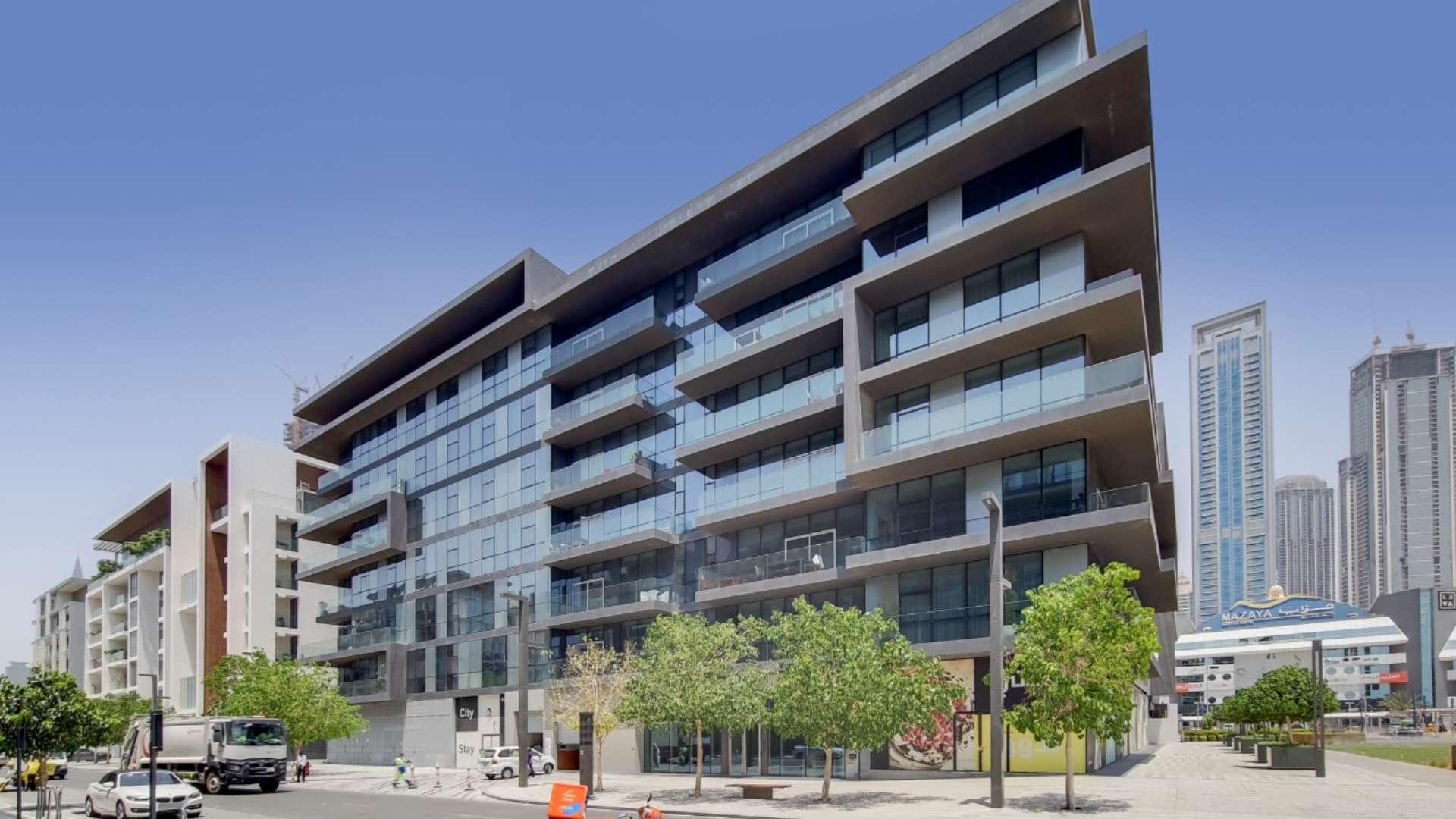 Modern furnished living area in City Walk apartment with open kitchen and cozy seating