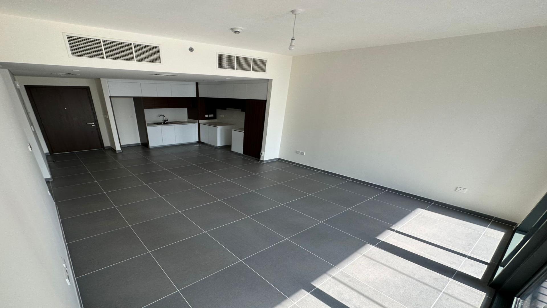 Modern living room with large windows in Creek Edge apartment, Dubai Creek Harbour