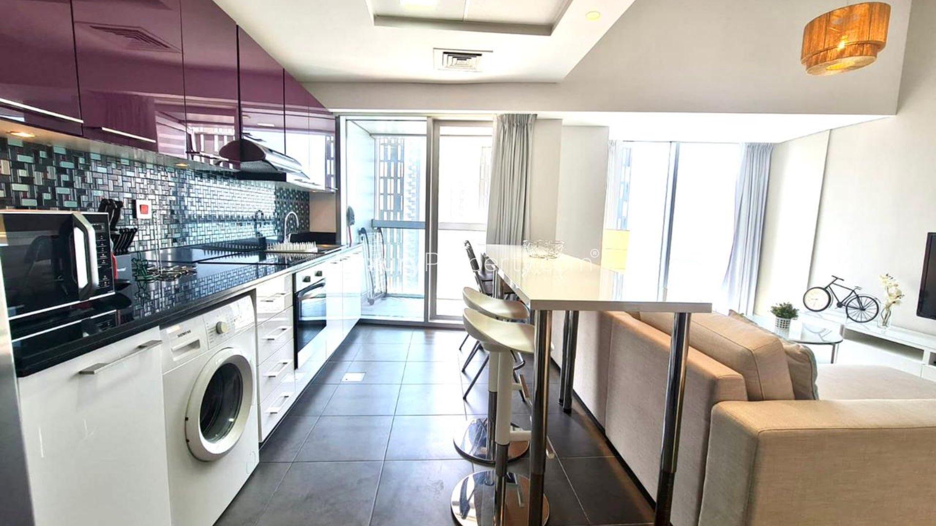 Modern living room in 1-bedroom apartment, Cayan Tower, Dubai Marina, featuring open kitchen