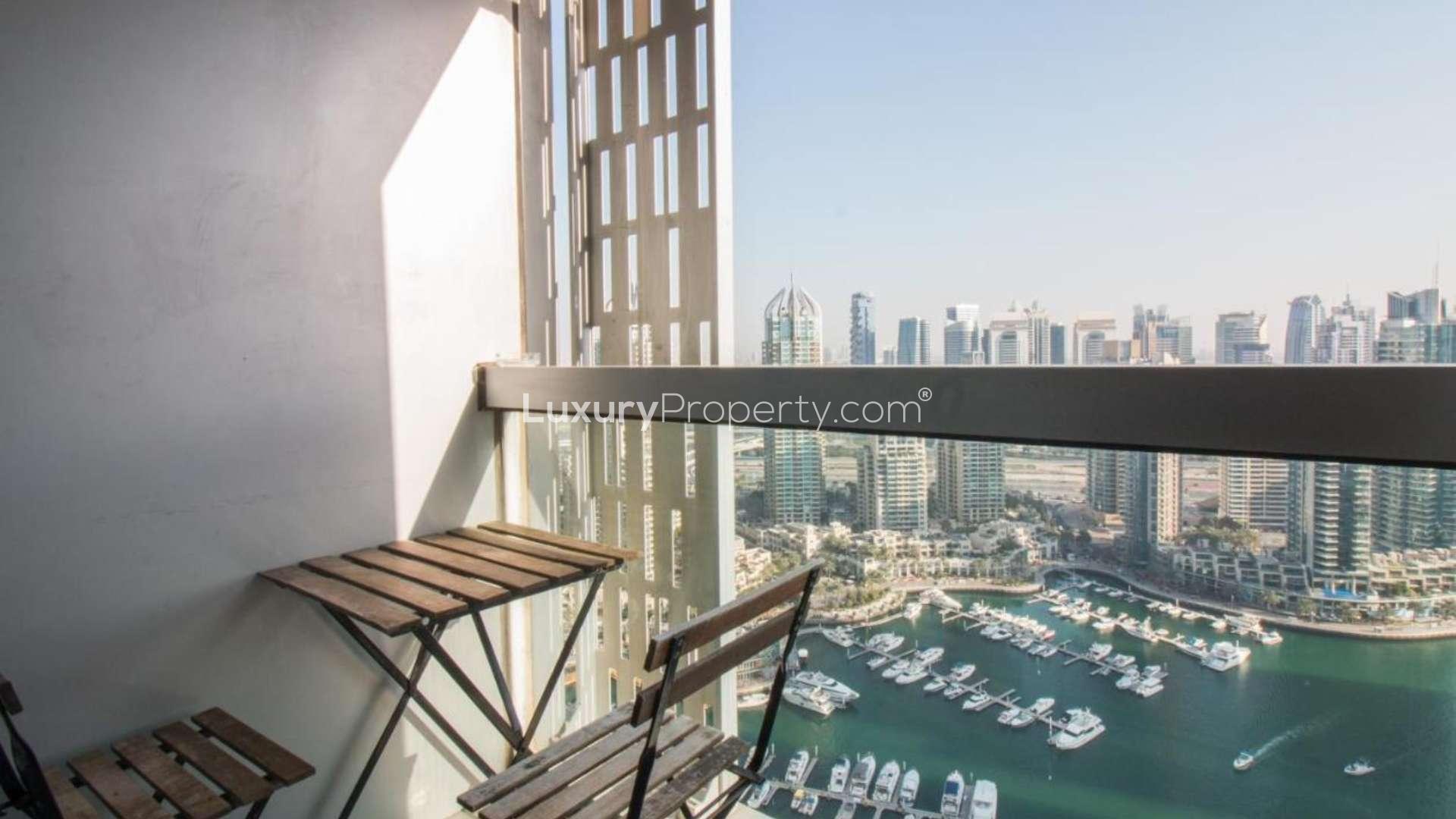 Modern furnished living area in Dubai Marina apartment, featuring kitchen and large windows