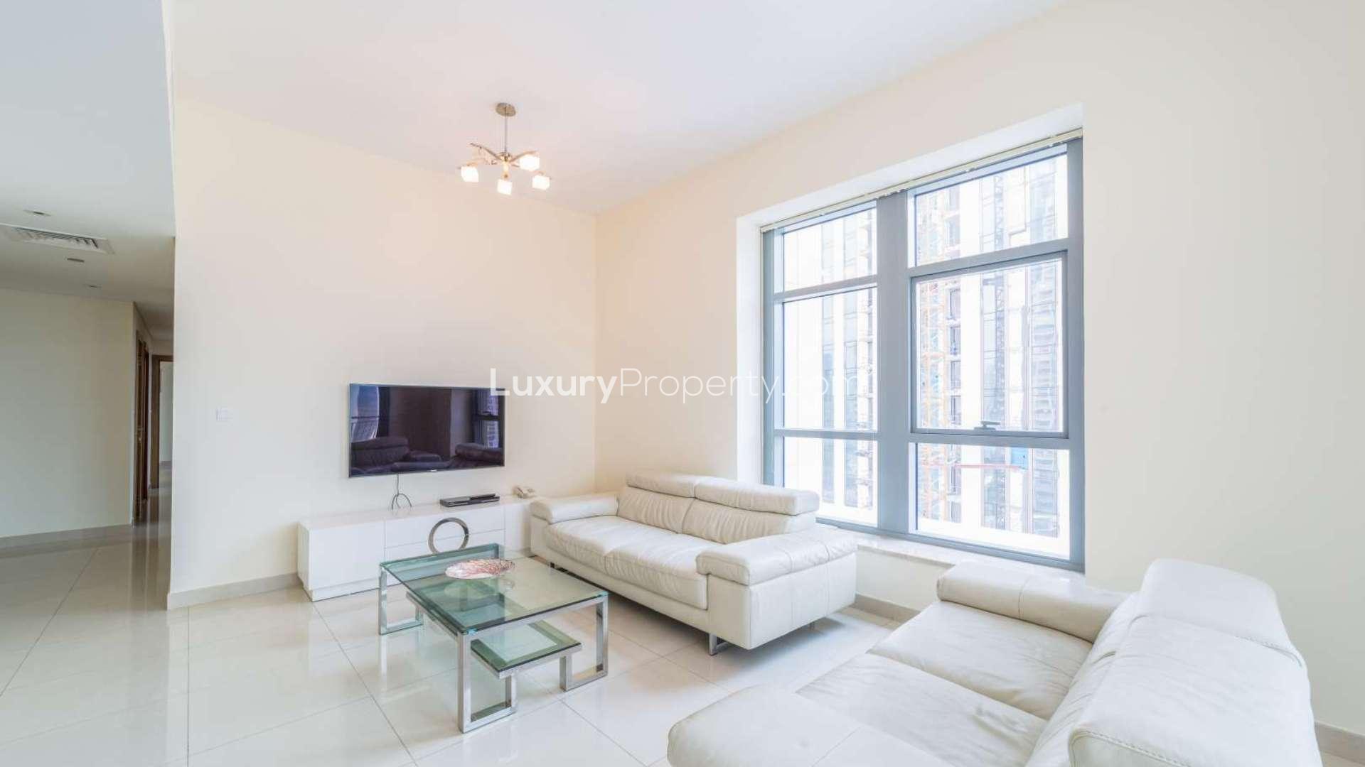 "Bright living room in Downtown Dubai apartment, Claren Towers, with modern furniture and large window.",Modern fitted kitchen in Downtown Dubai apartment for rent at Claren Towers