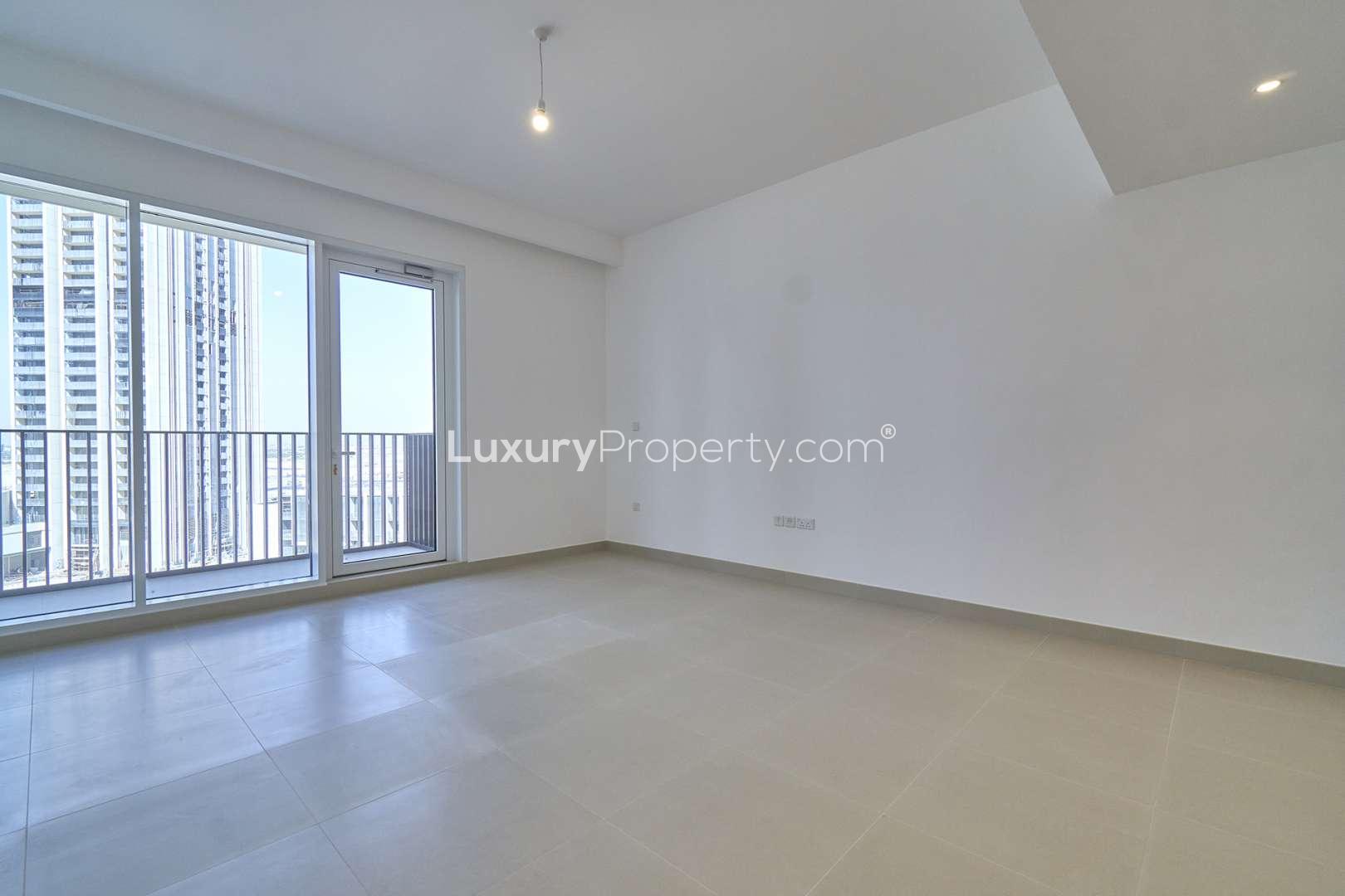 Empty living room in modern Dubai Creek Harbour apartment with large windows