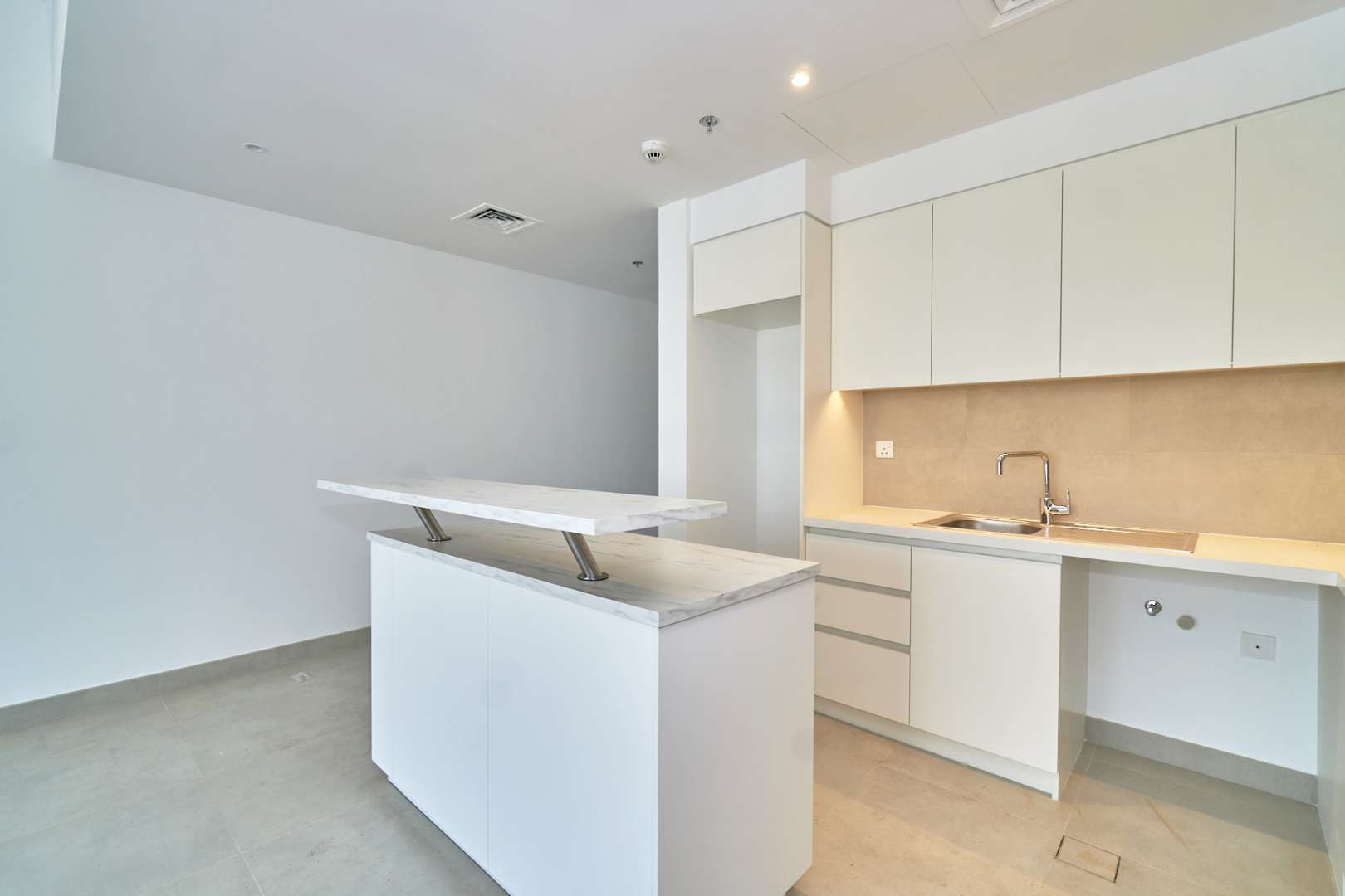 Empty living room in Dubai Creek Harbour apartment with large windows and city view