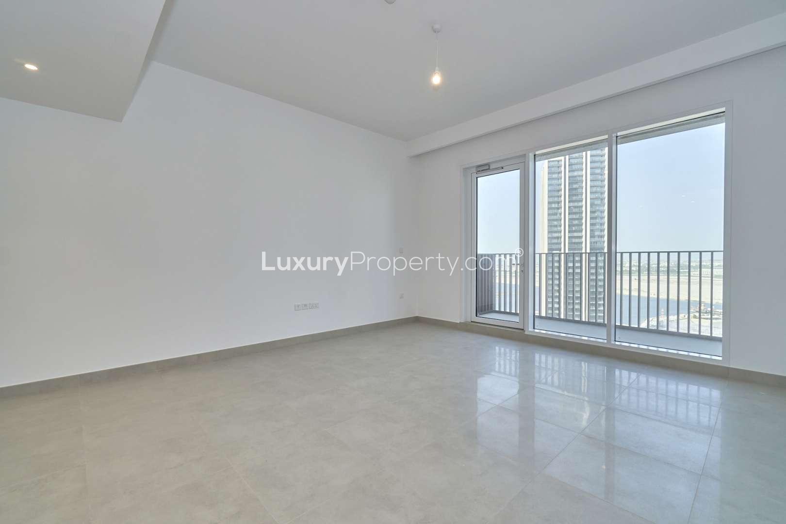 Empty high-floor apartment living area with balcony in Creek Horizon, Dubai Creek Harbour