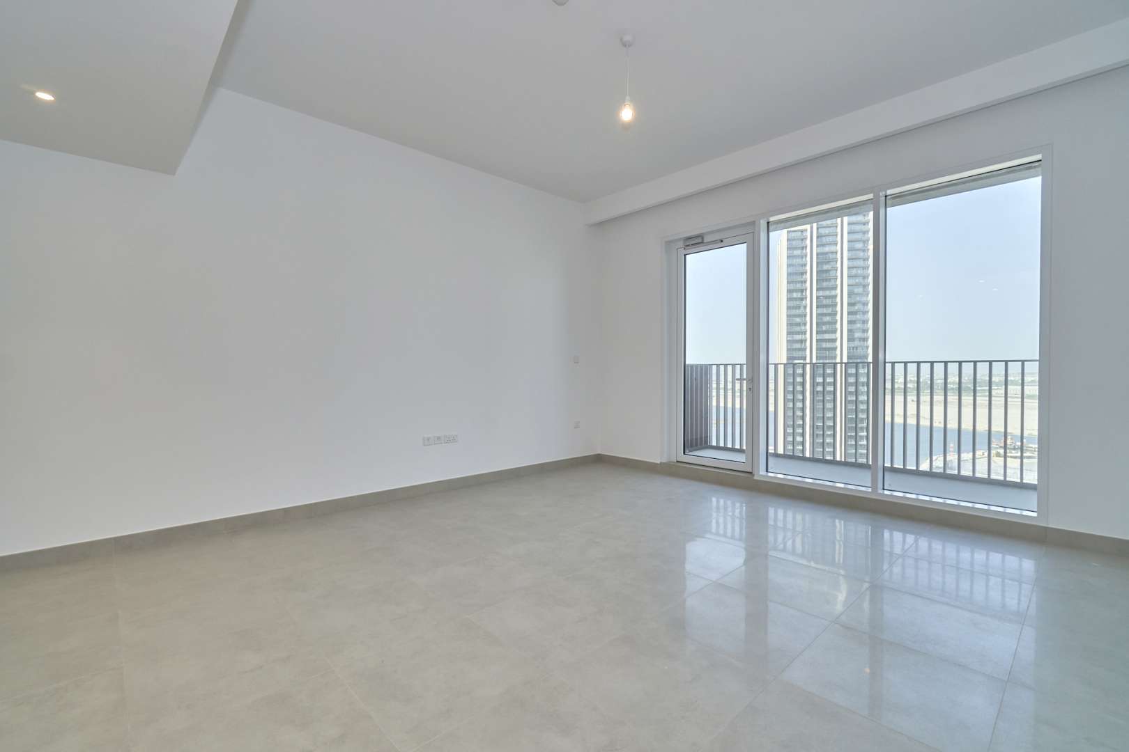Empty high-floor apartment living area with balcony in Creek Horizon, Dubai Creek Harbour