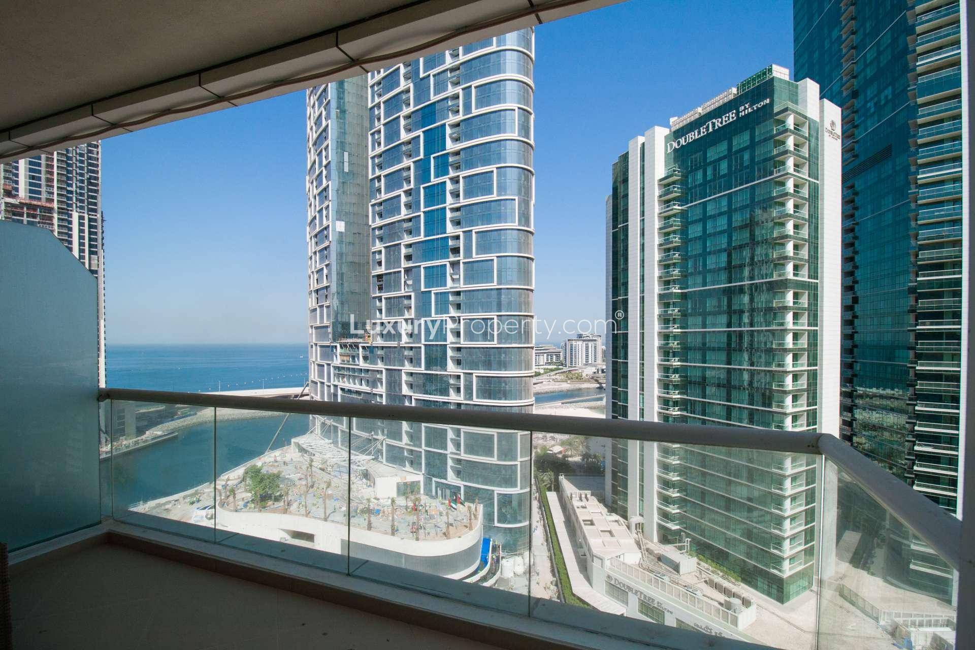 "View from Dorra Bay apartment balcony overlooking Dubai Marina skyline and sea.",Modern kitchen and living area in 1-bedroom apartment, Dorra Bay, Dubai Marina