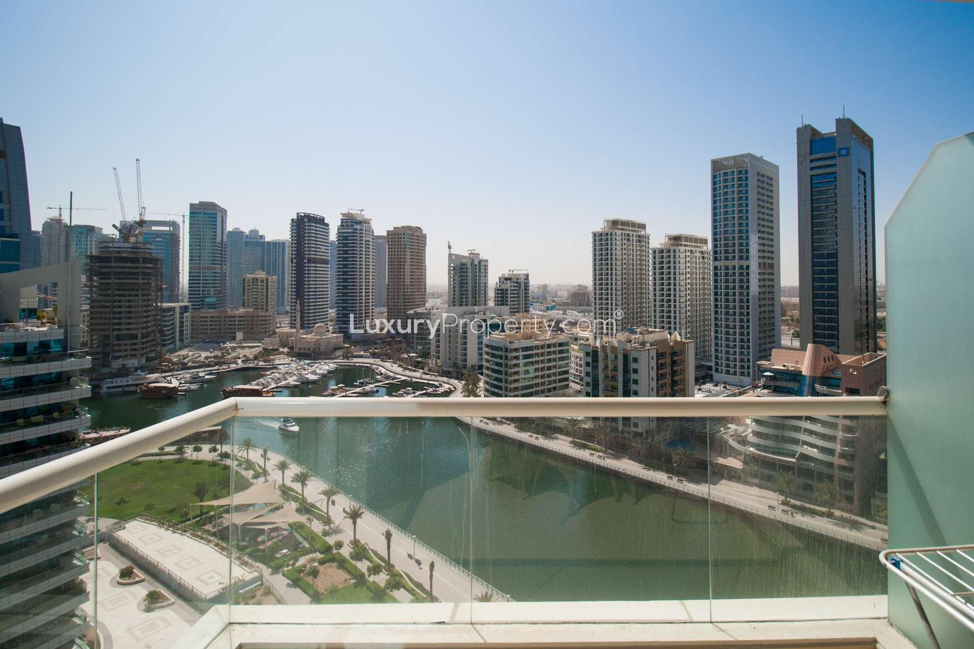 Outdoor swimming pool area at Dorra Bay apartment, Dubai Marina, with modern high-rise buildings