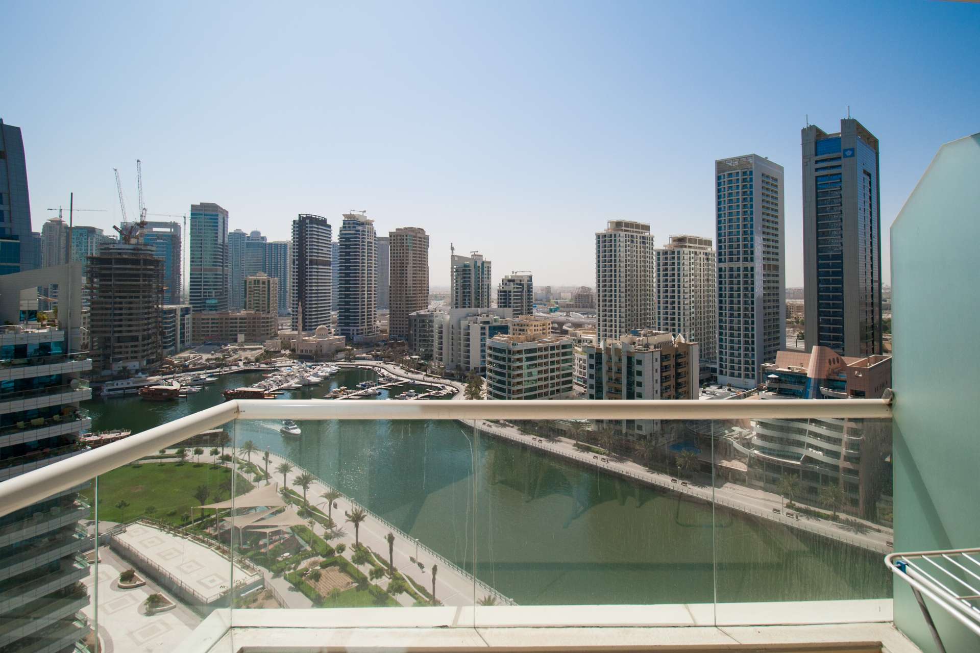 Outdoor swimming pool area at Dorra Bay apartment, Dubai Marina, with modern high-rise buildings