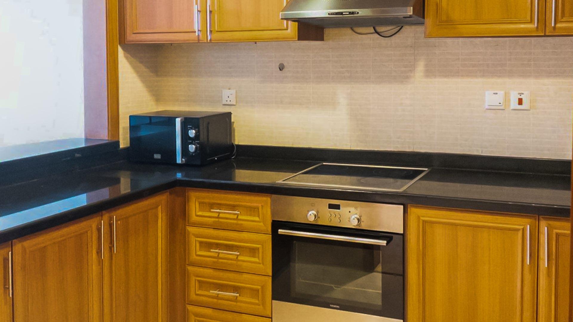 Modern kitchen with wooden cabinets in Dubai Marina one-bedroom apartment for rent, Dorra Bay