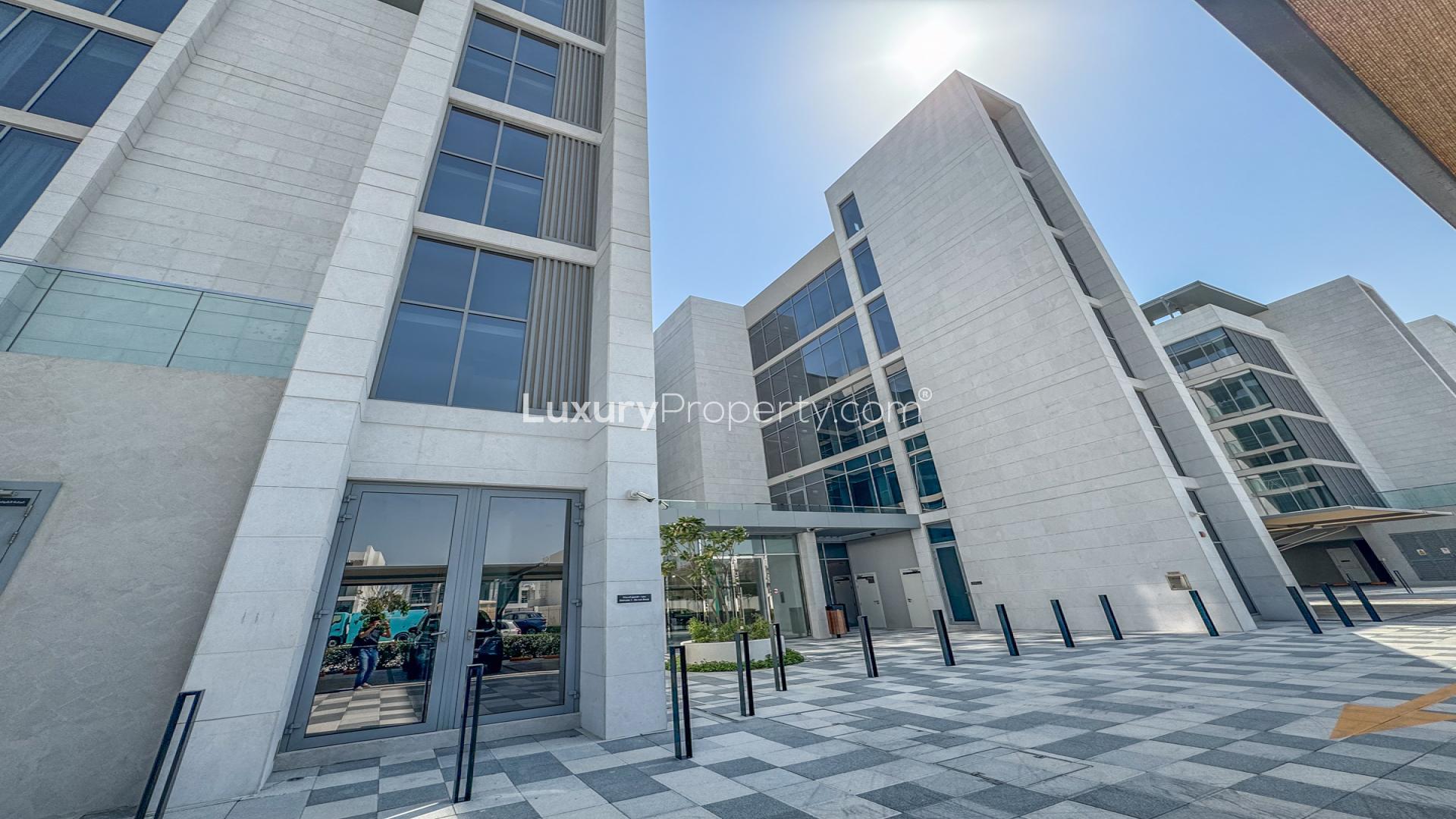 "Balcony view of lagoon from furnished 1-bedroom apartment in District One, Mohammed Bin Rashid City.",Exterior of modern apartment building in District One, Mohammed Bin Rashid City, for rent