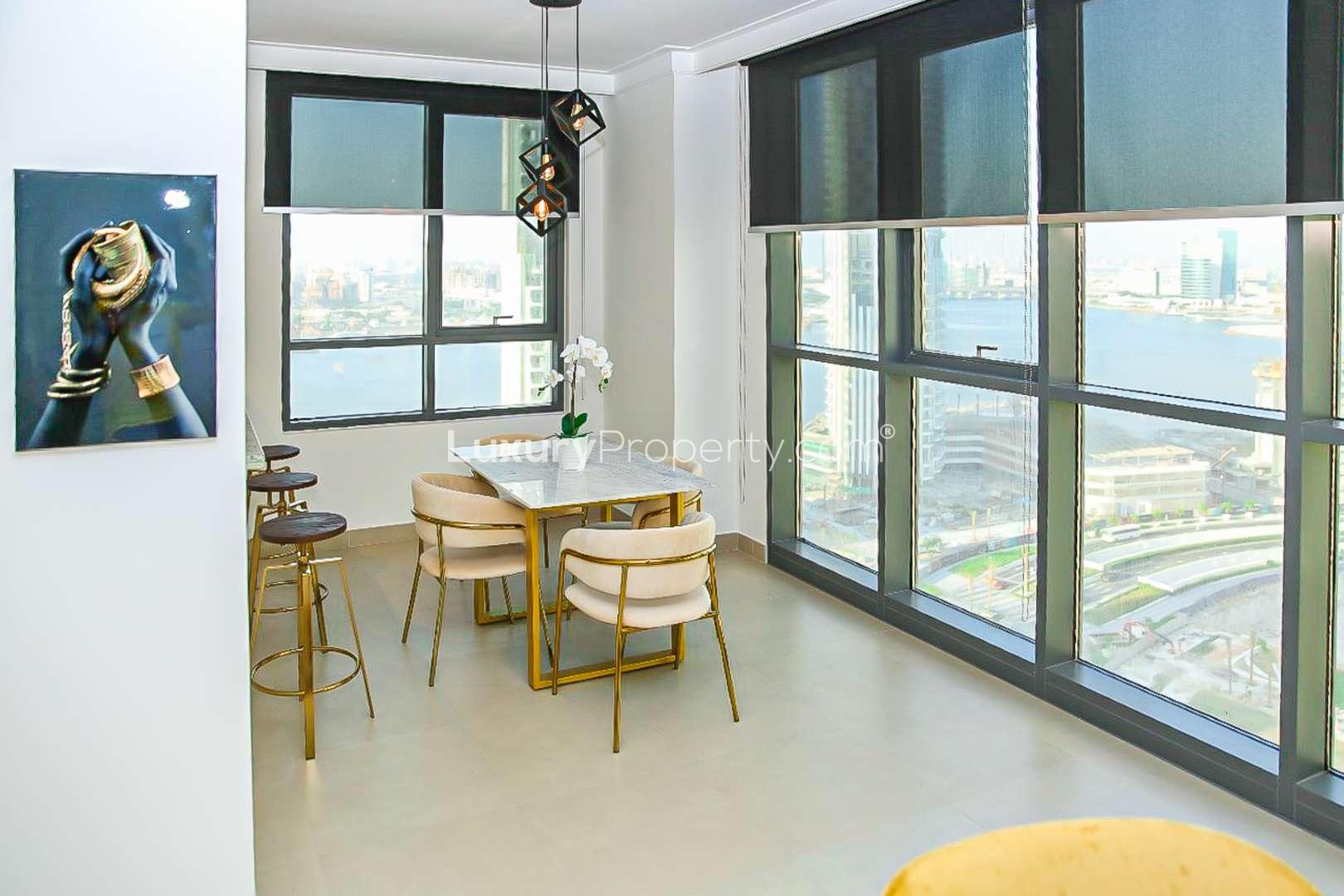 Fully furnished living room in Dubai Creek Harbour apartment, featuring modern decor and large windows