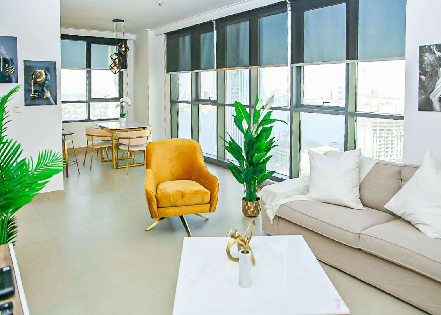 Modern furnished living room in 1-bedroom apartment, Dubai Creek Harbour, with large windows and plants