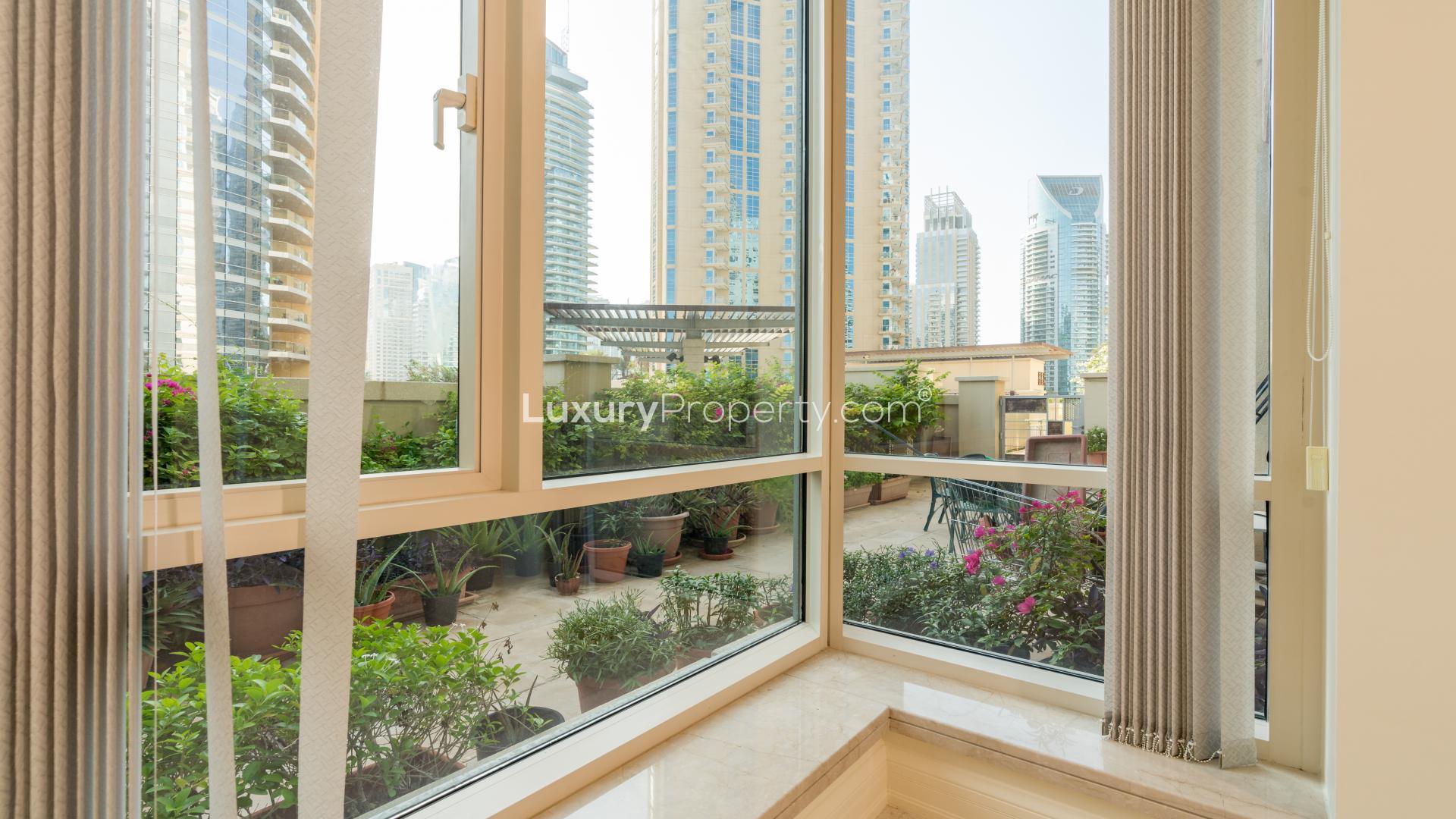 Furnished living room in Dubai Marina apartment, Emaar 6 Towers, with garden view