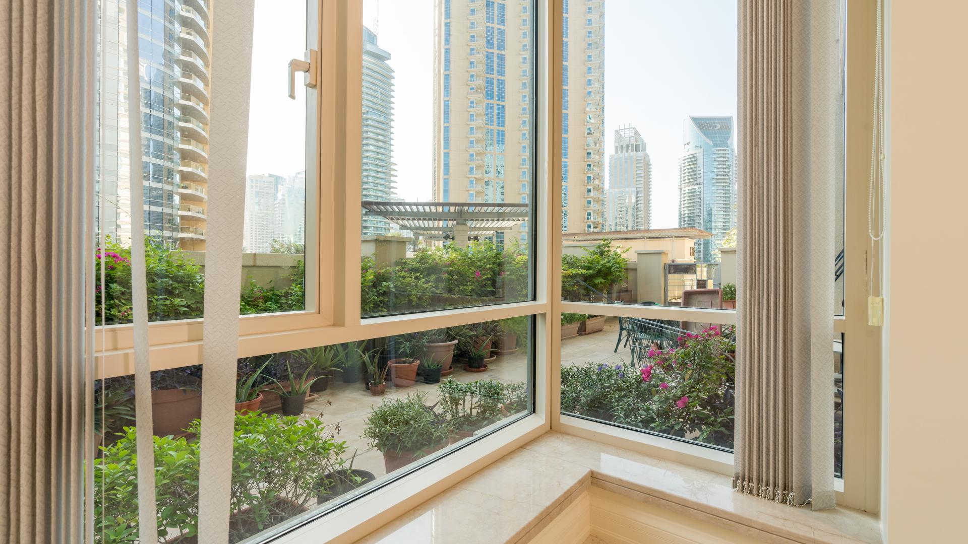 Furnished living room in Dubai Marina apartment, Emaar 6 Towers, with garden view