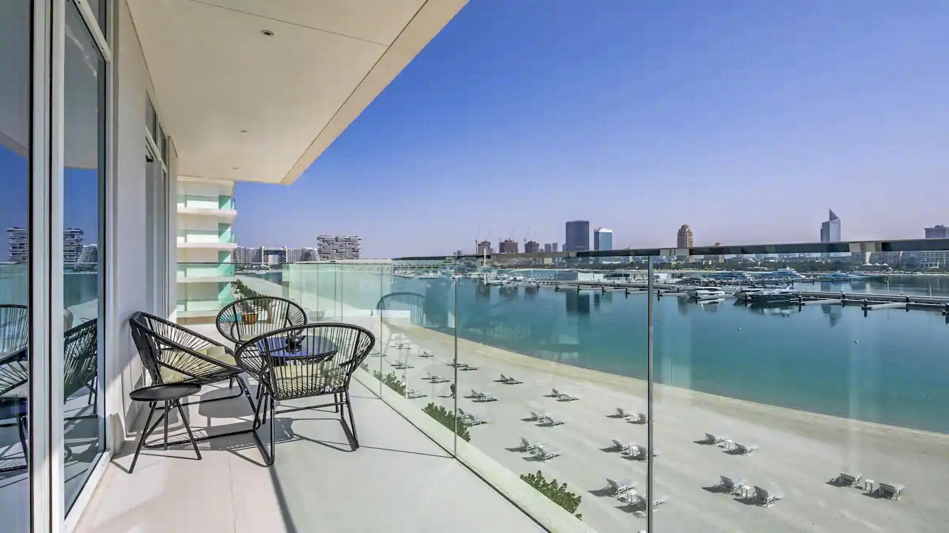 Furnished apartment living room in Emaar Beachfront, Dubai Harbour, with modern decor and kitchen