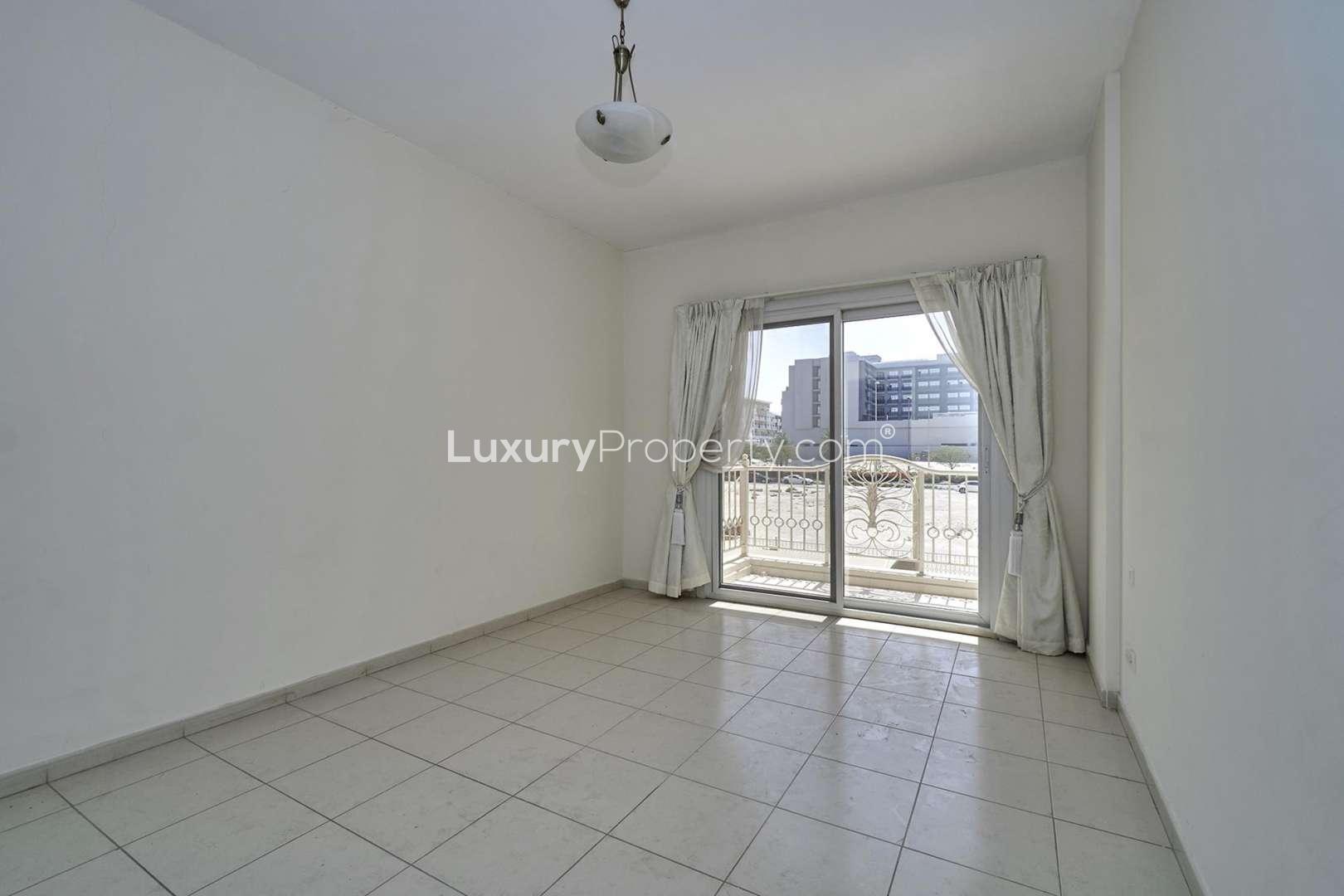 Empty living room in JVC apartment with tiled floor and large window view