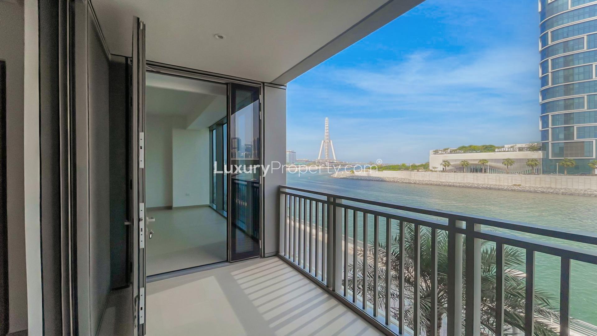 Empty living area in luxury Dubai Marina apartment with modern kitchen and balcony access