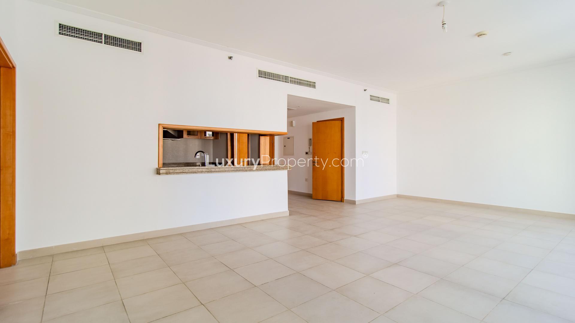 Spacious living area in Dubai Marina apartment with open kitchen and large windows
