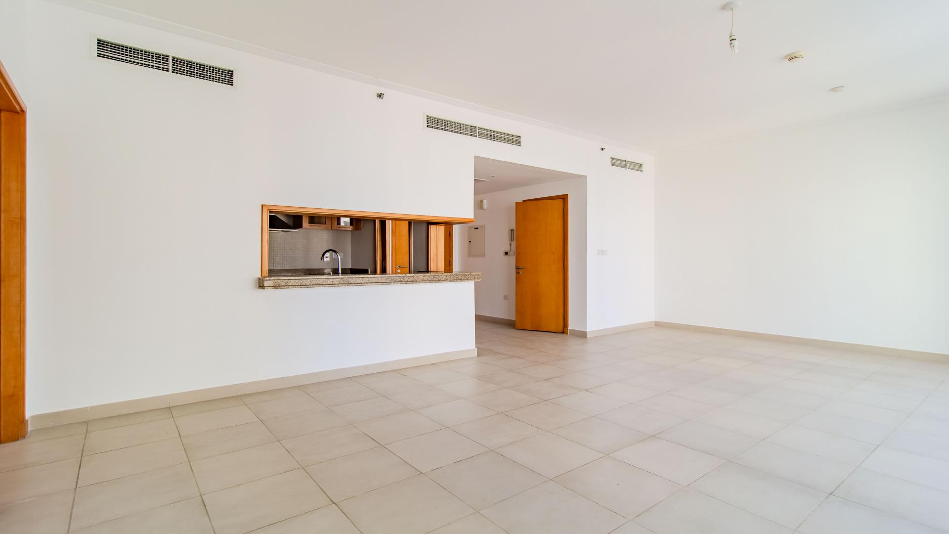 Spacious living area in Dubai Marina apartment with open kitchen and large windows