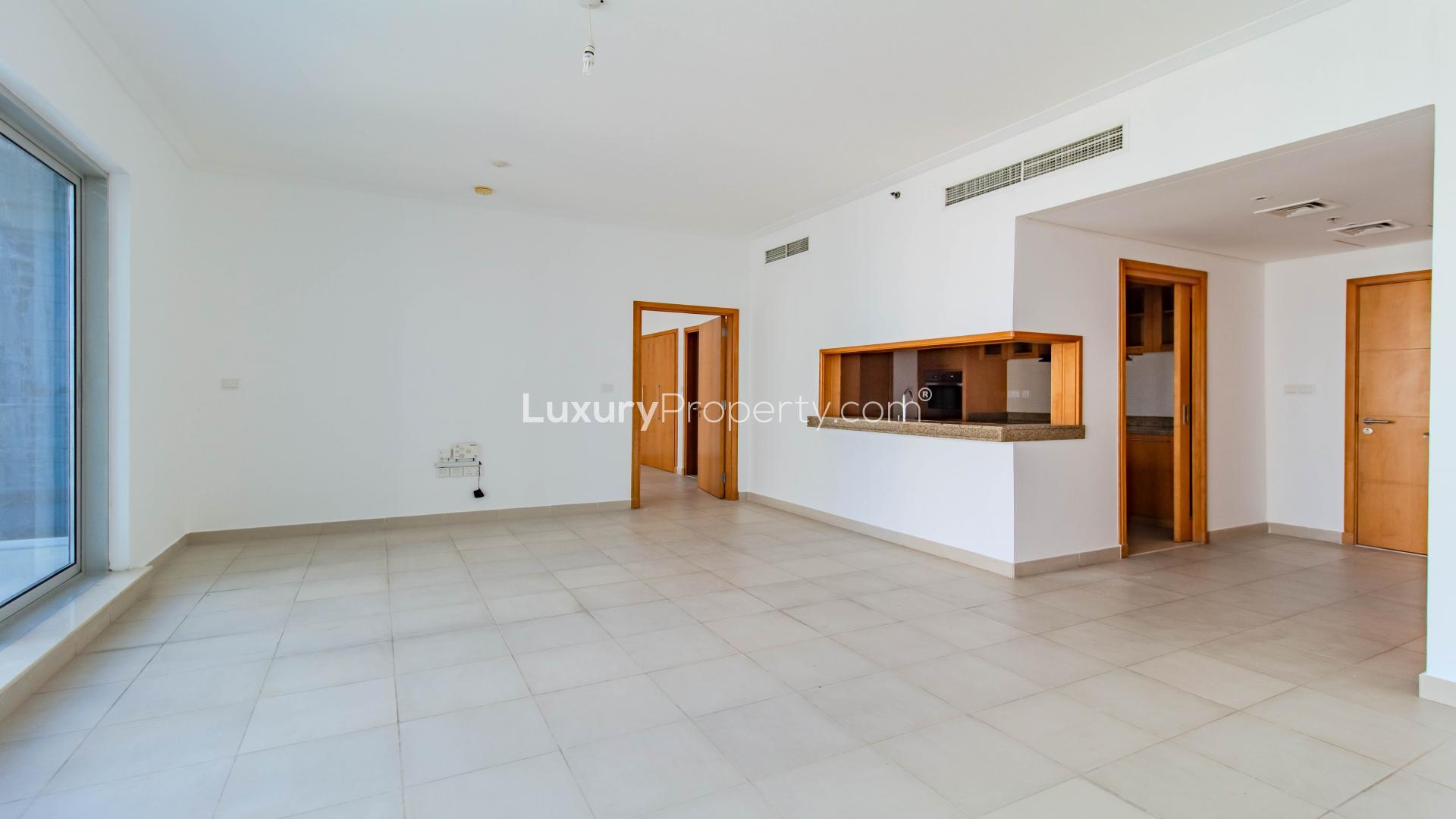 Spacious living area in Dubai Marina apartment with modern kitchen and large windows