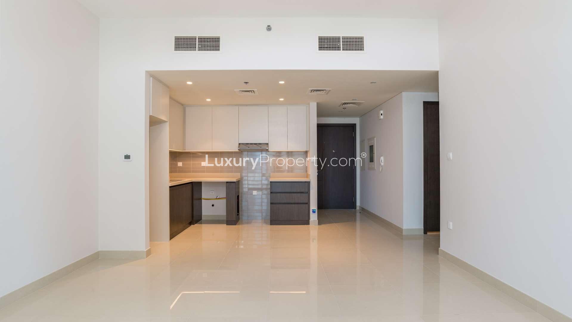 Empty living area with balcony and kitchen in Harbour Views 1, Creek Harbour apartment