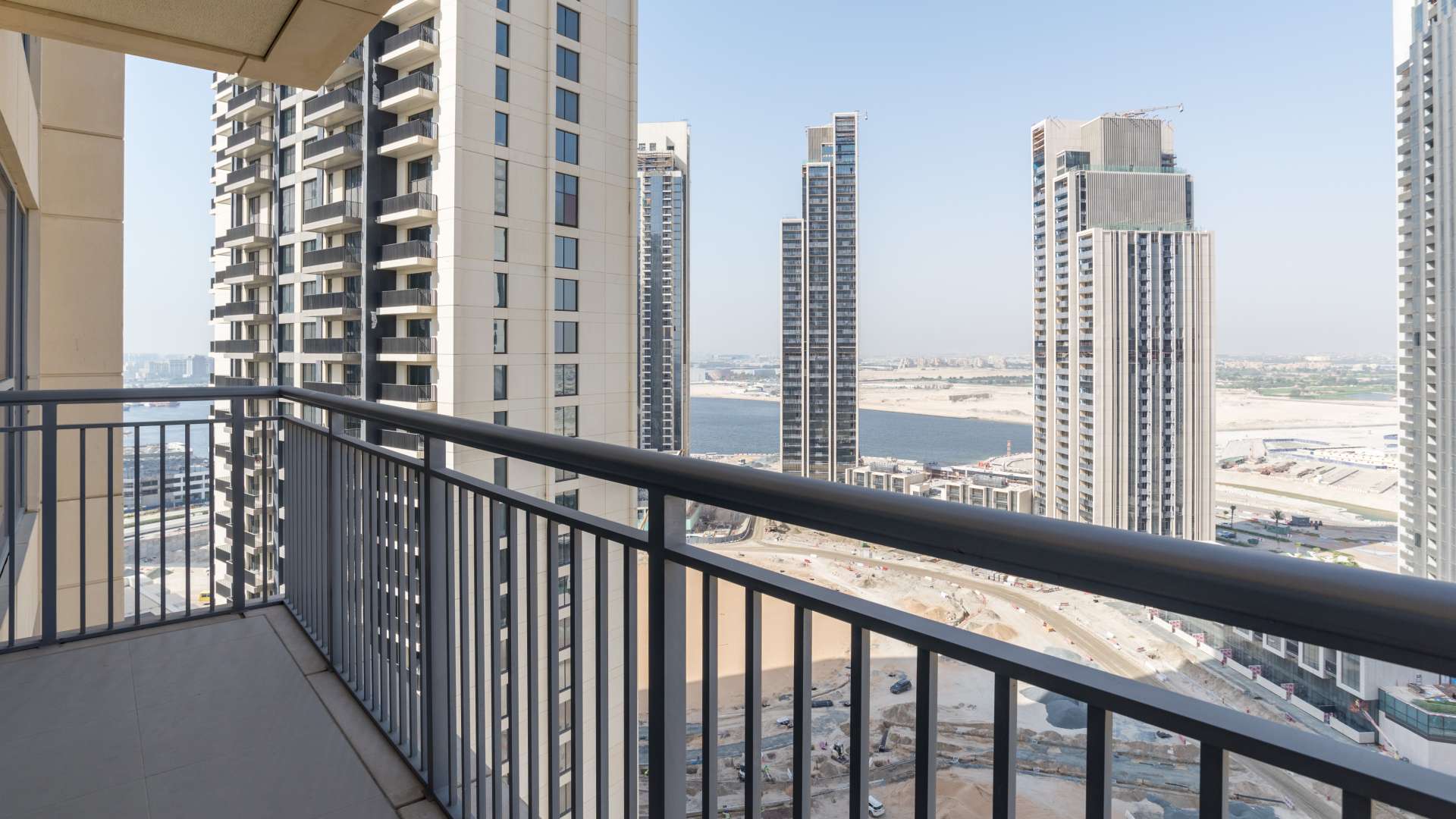 Empty modern apartment with large windows overlooking Dubai Creek Harbour skyline