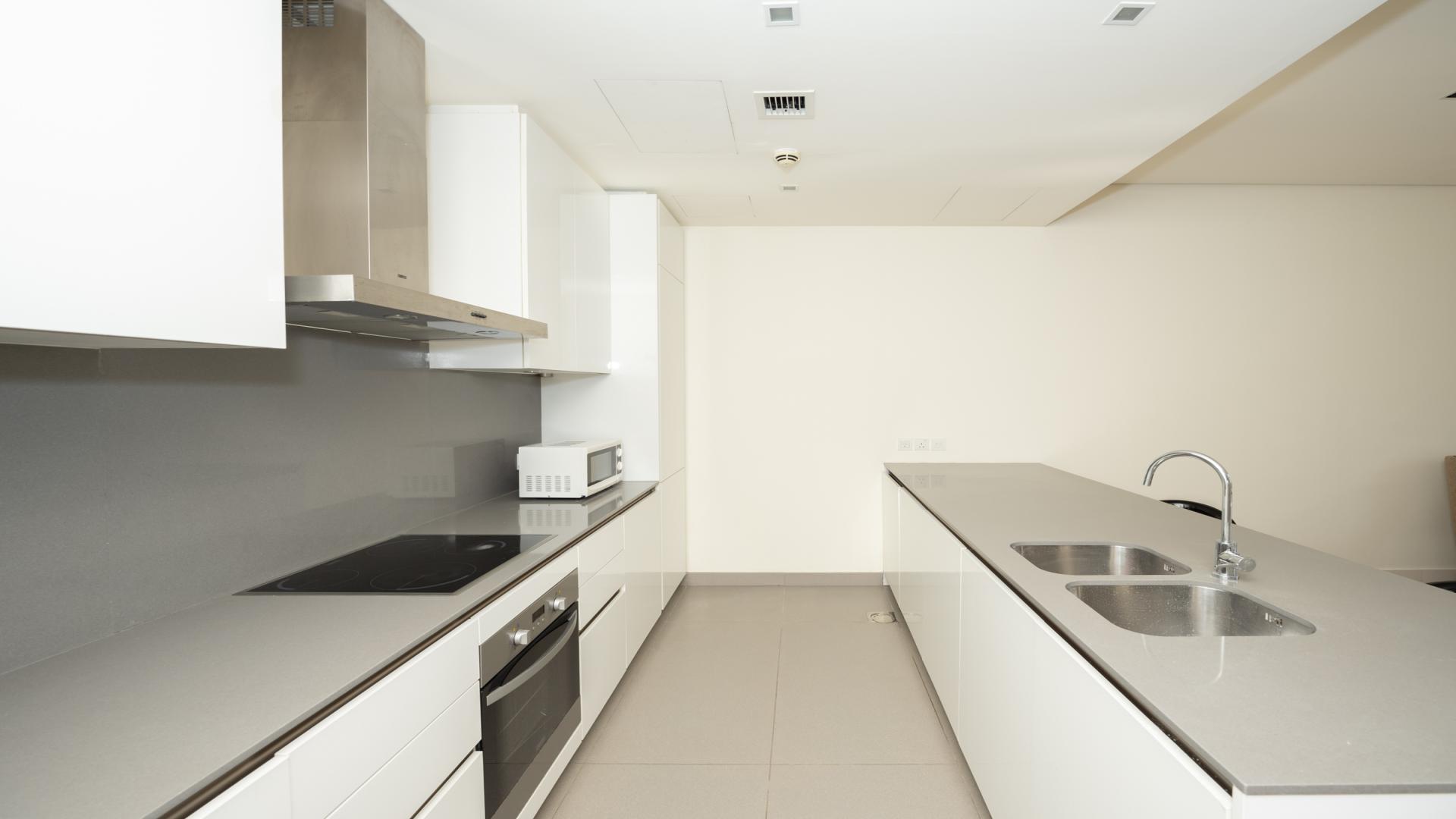 Modern kitchen with island and sleek finishes in City Walk apartment, Building 20