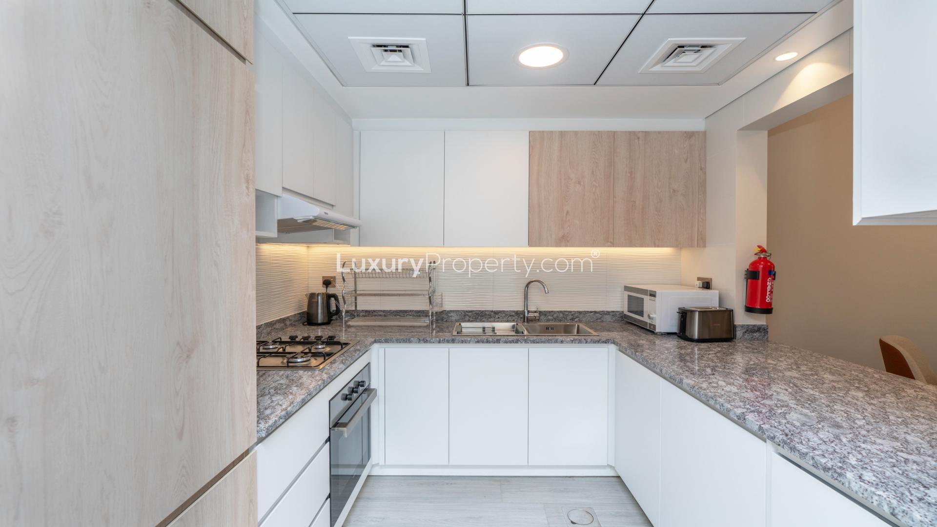 Furnished living room in Business Bay apartment, modern decor, large windows, cozy seating area