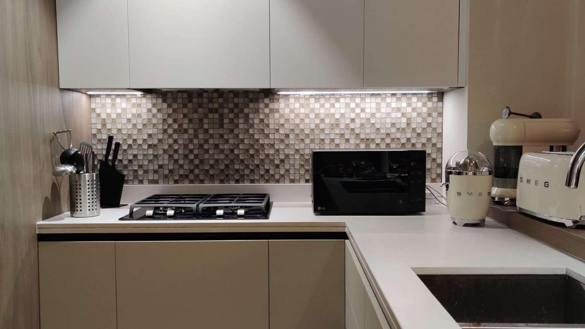 Tall residential towers in Marina Gate, Dubai Marina with palm trees and clear sky