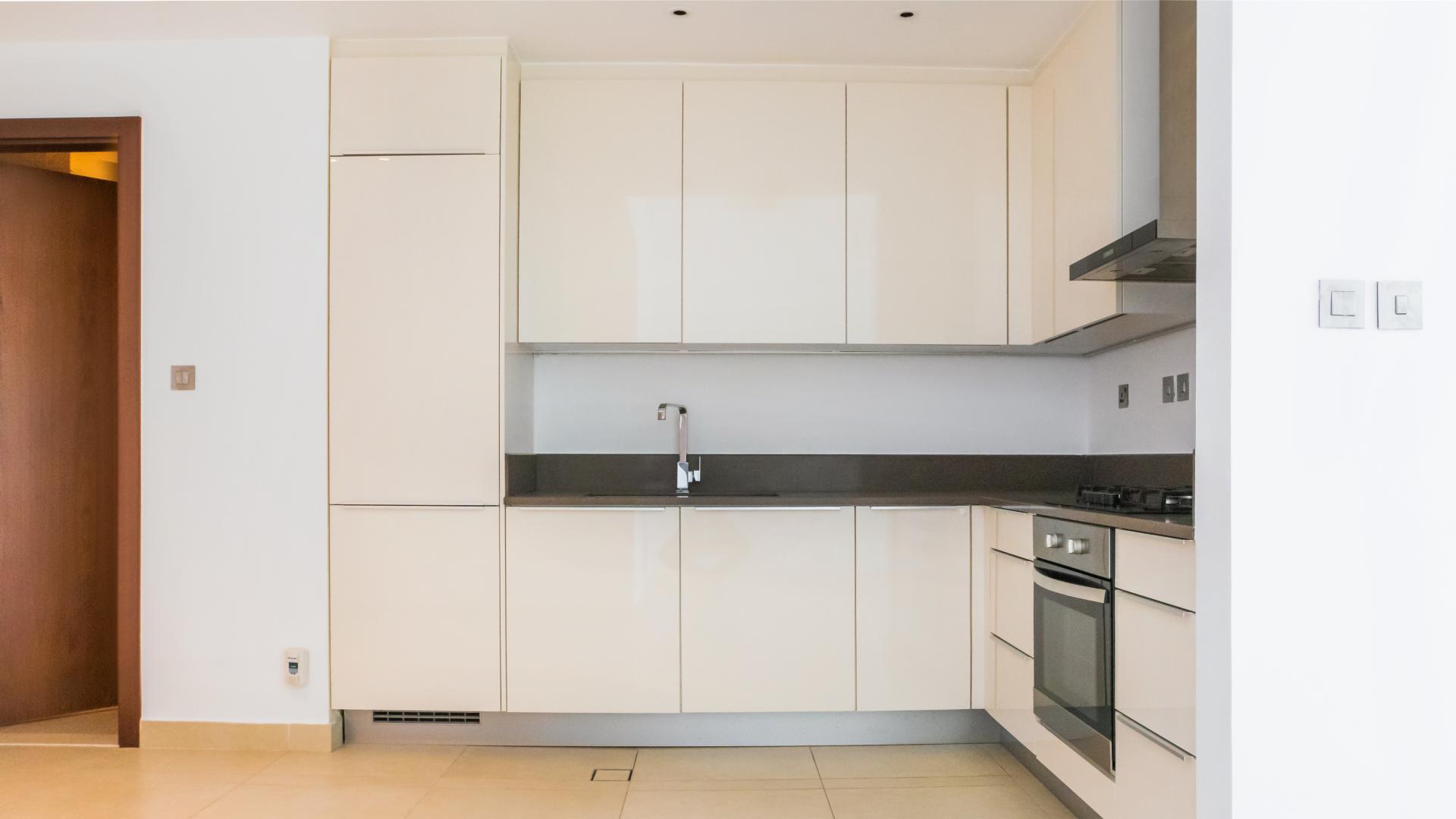 Modern kitchen in Dubai Marina apartment, featuring sleek cabinetry and built-in appliances