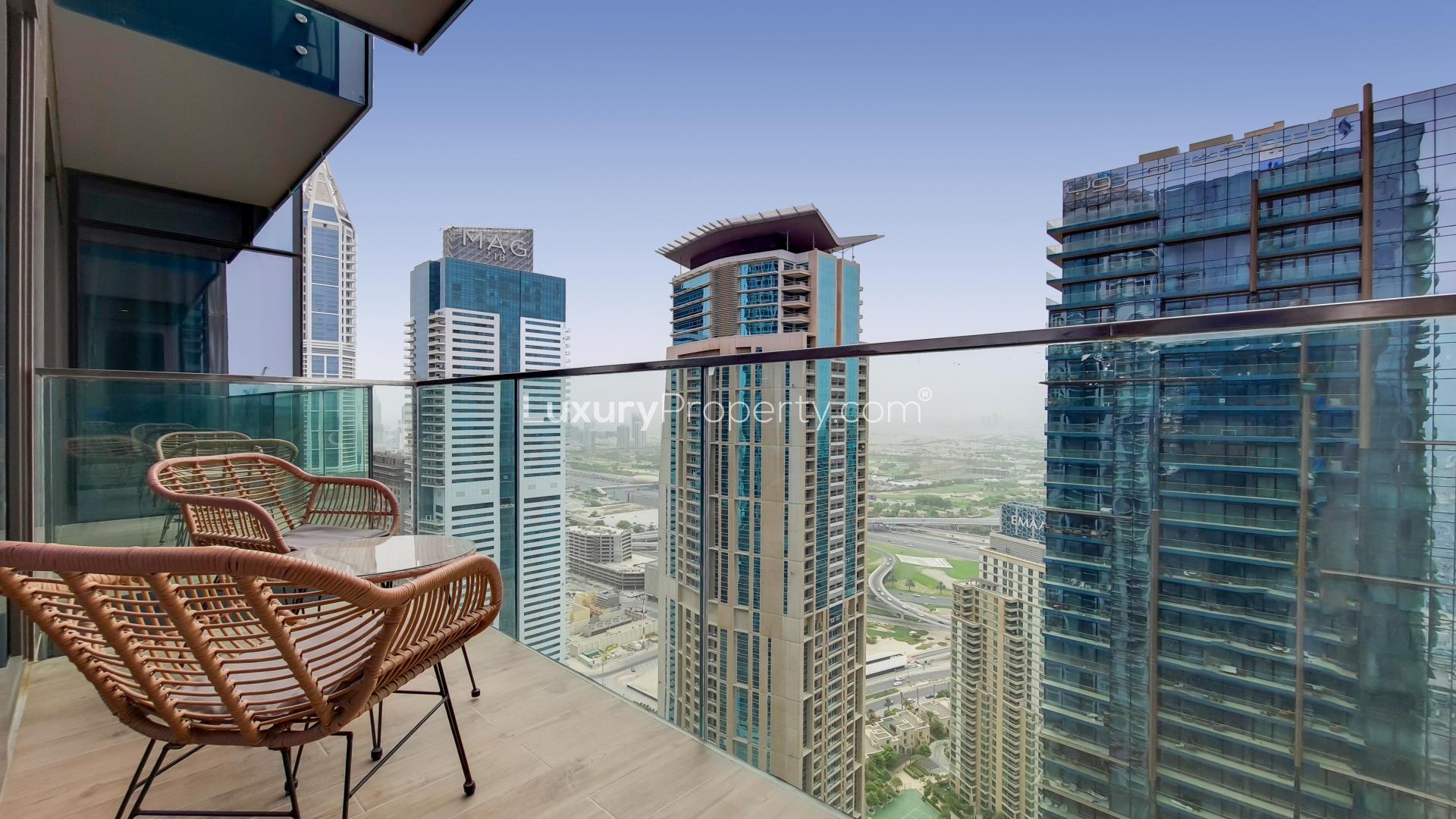 Modern living room with marina views, glass table, and TV in Dubai Marina apartment